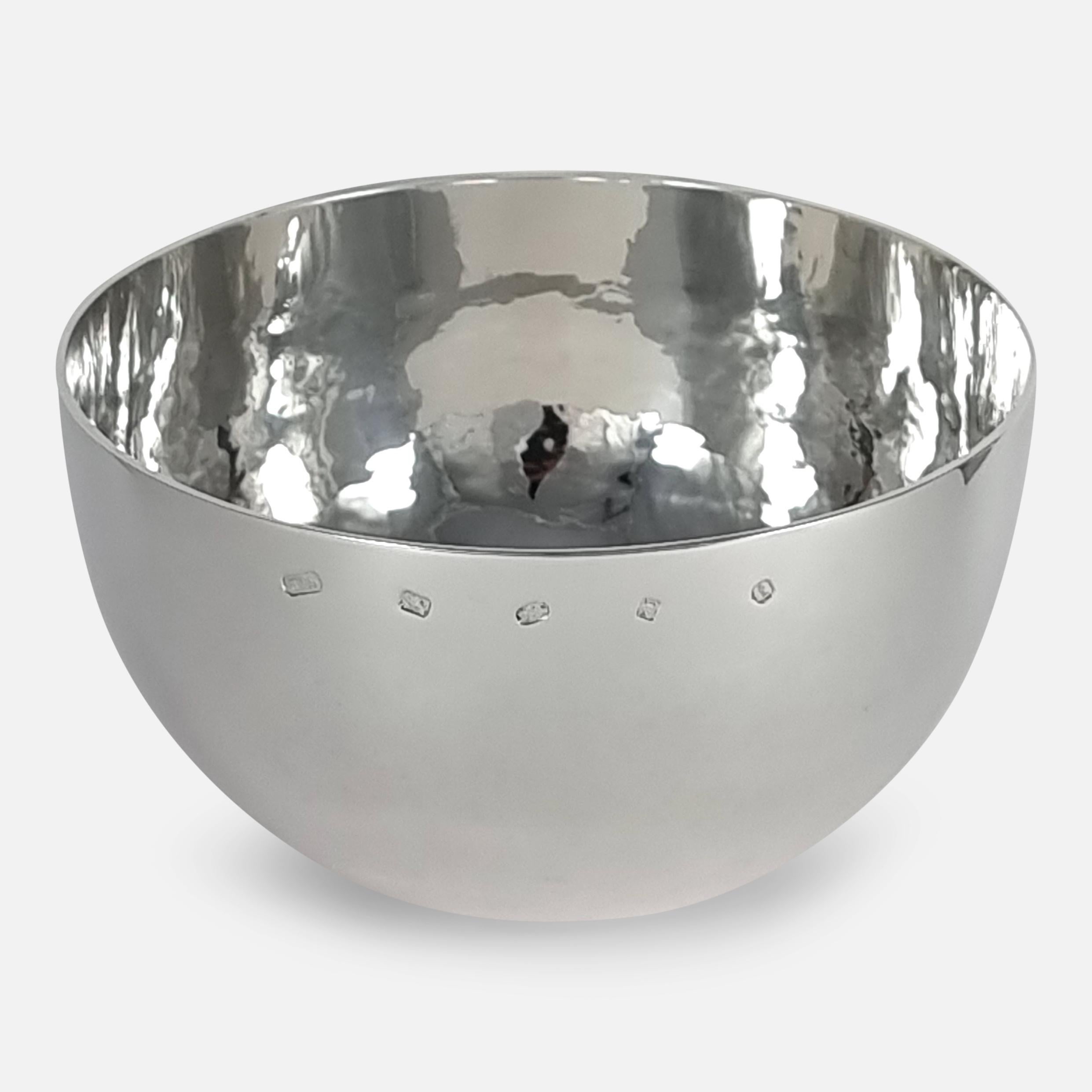 An Elizabeth II sterling silver tumble fruit bowl. The planished silver bowl is crafted in the style of an oversized tumbler cup.

It is hallmarked with the makers mark of William & Son (William Asprey), with London assay marks, and date letter 't'