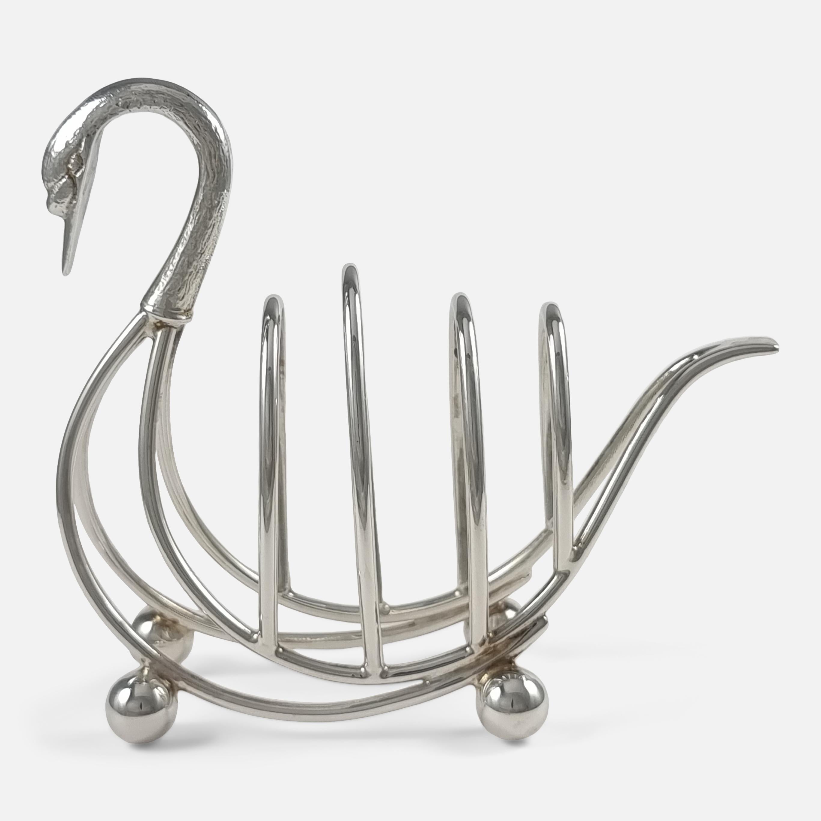 A charming Elizabeth II era sterling silver toast rack, crafted by Bishton's Ltd in 1971, Birmingham. This unique piece is shaped like a swan, complete with three divisions for toast, and stands on four spherical feet for stability.

• Measurement: