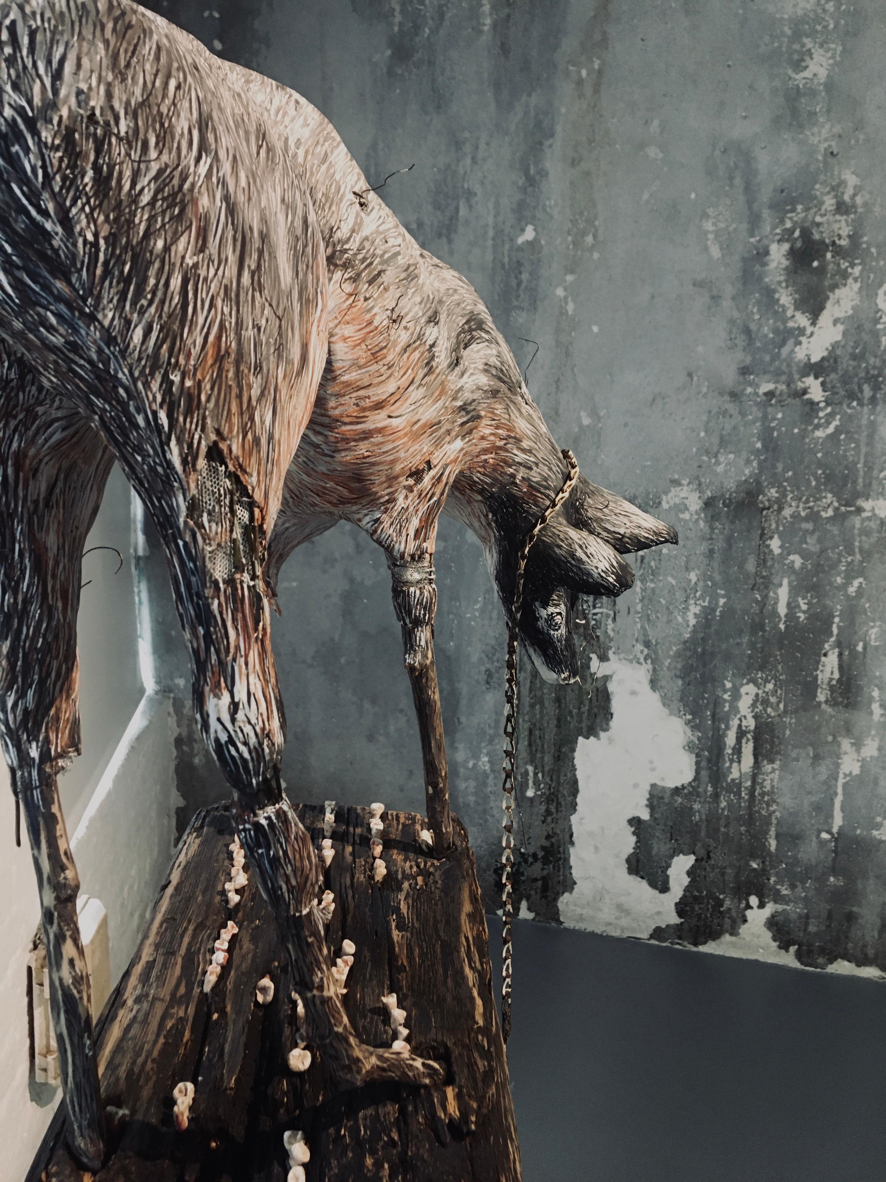 Sculpture d'un loup sur une plate-forme en bois avec une chaîne : 