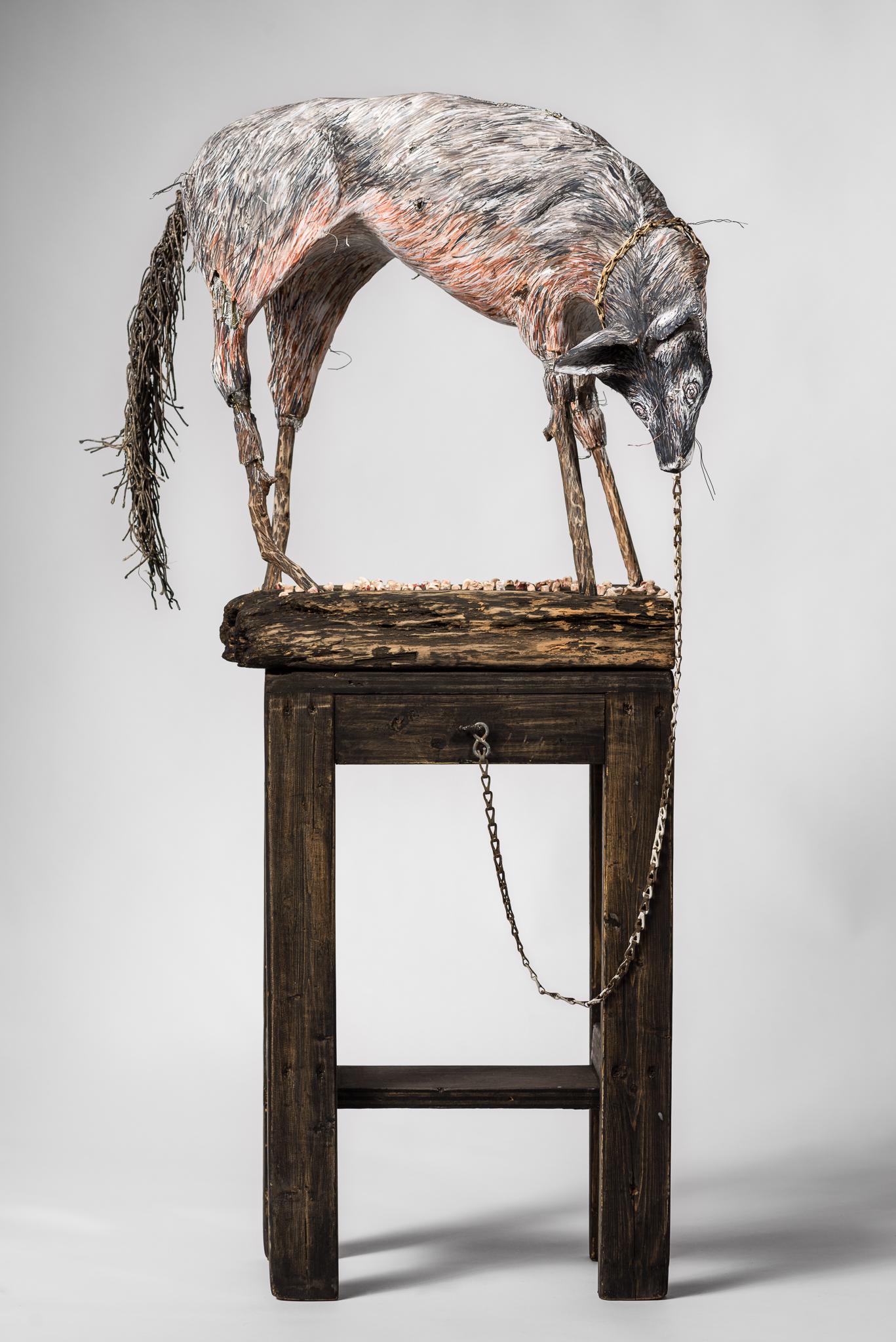 Sculpture d'un loup sur une plate-forme en bois avec une chaîne : "Let go and let God" (Lâcher prise et laisser Dieu)