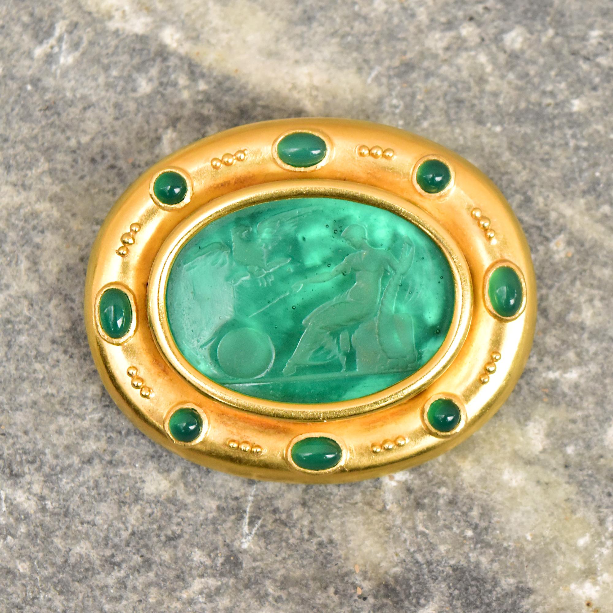 An incredible 18K venetian glass intaglio cameo brooch pendant by renowned jewelry designer Elizabeth Locke. Features a gorgeous carved green cameo set in a robust yellow gold oval frame with green cabochons decoration and gold bead accents.

The