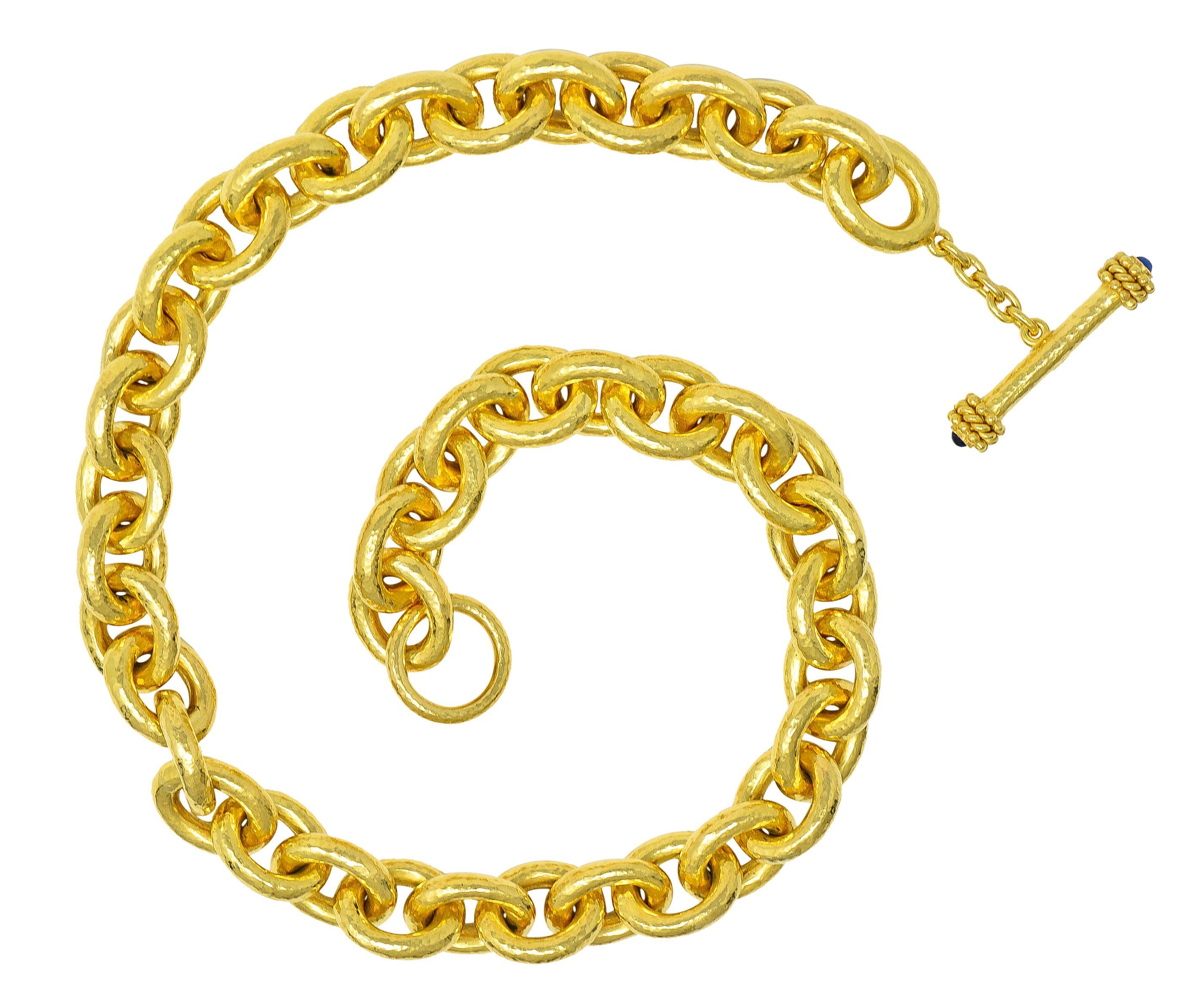 Designed as a cable link chain comprised of large oval-shaped links 
With very fine hammered texture throughout 
Completed by a stylized toggle clasp closure 
With gold bead and twisted rope terminals 
Capped with 3.0 mm round sapphire