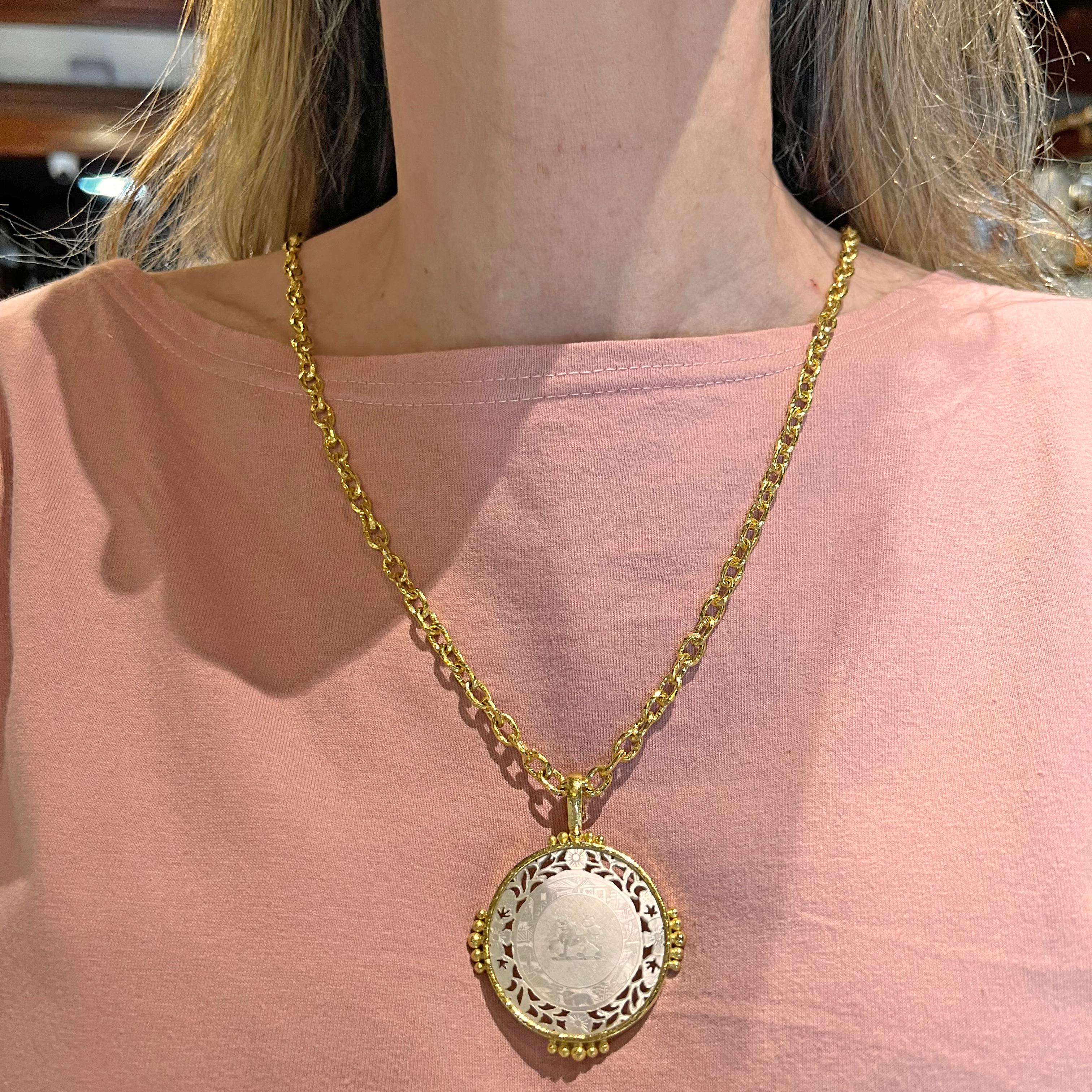This Elizabeth Locke pendant features a circular-shaped mother-of-pearl Chinese gambling counter bezel-set in 19k yellow gold. The delicate piercings and intricate carvings, create a stunning visual effect, bringing a touch of old-world charm to the