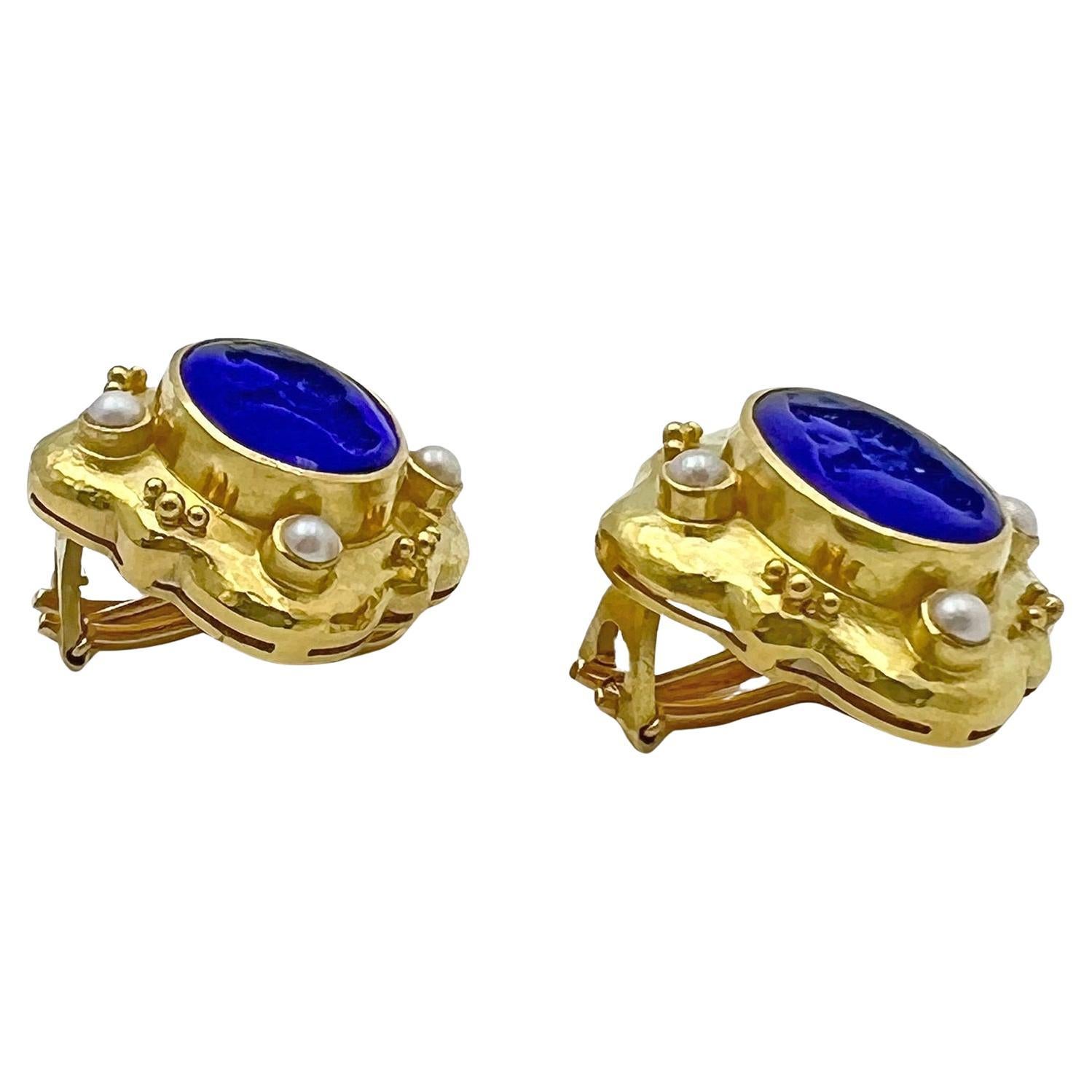 Elizabeth Locke handmade 19k yellow gold earrings, each centering a bezel-set dark blue Venetian glass intaglio motif of a bear, further accented by small cultured pearl accents at the cardinal points. Mother-of-pearl backs the intaglios. Omega clip