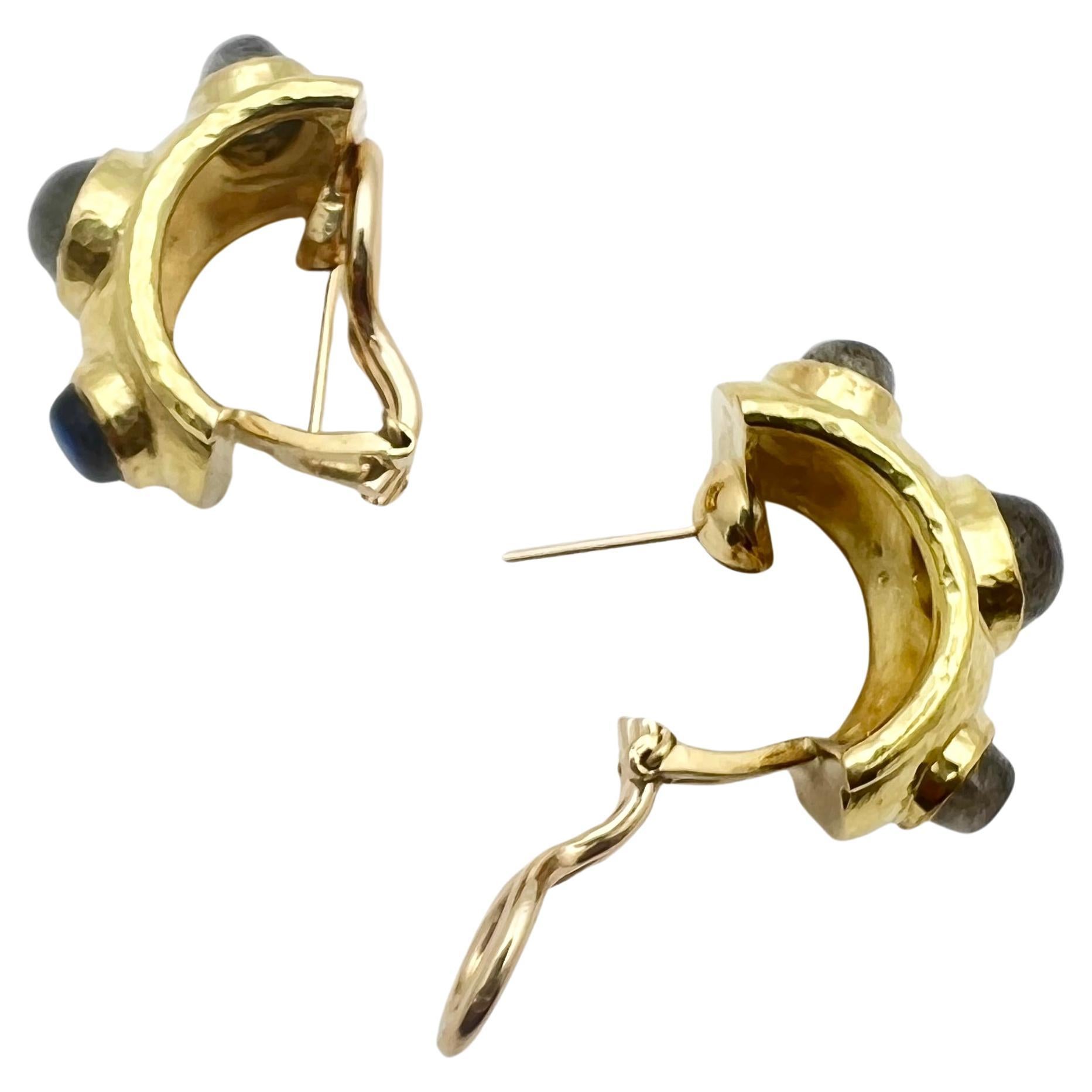 Elizabeth Locke labradorite half-hoop earrings in 19k yellow gold. Hammered half hoop design with omega clip backs and optional hinged, fold-down posts for pierced wearers. 
 Each earring bezel-set with three cabochon oval labradorites (two 9 x 6mm
