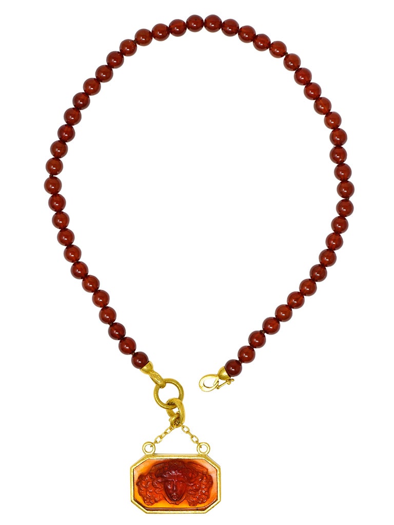 Necklace is designed as strand of 8.0 mm round carnelian beads suspending octagonal enhancer pendant

Beads are well matched and translucent brownish red in color - deeply saturated

Pendant centers transparent orangey red Venetian glass