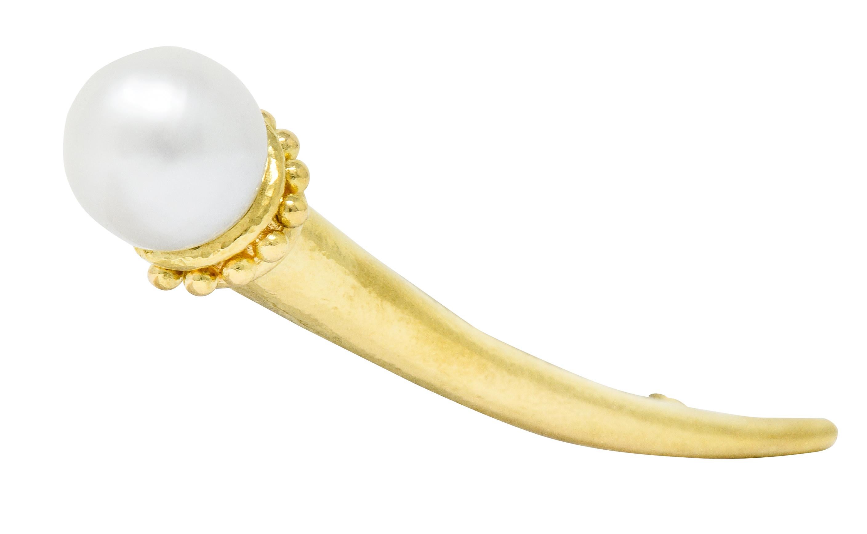 Brooch is designed as a stylized spiculum shaped talon with a very slight hammered finish

Terminating on one end as a decorative pearl cup featuring a gold bead motif

Topped by a 13.0 mm round cultured pearl, white in body color with strong silver