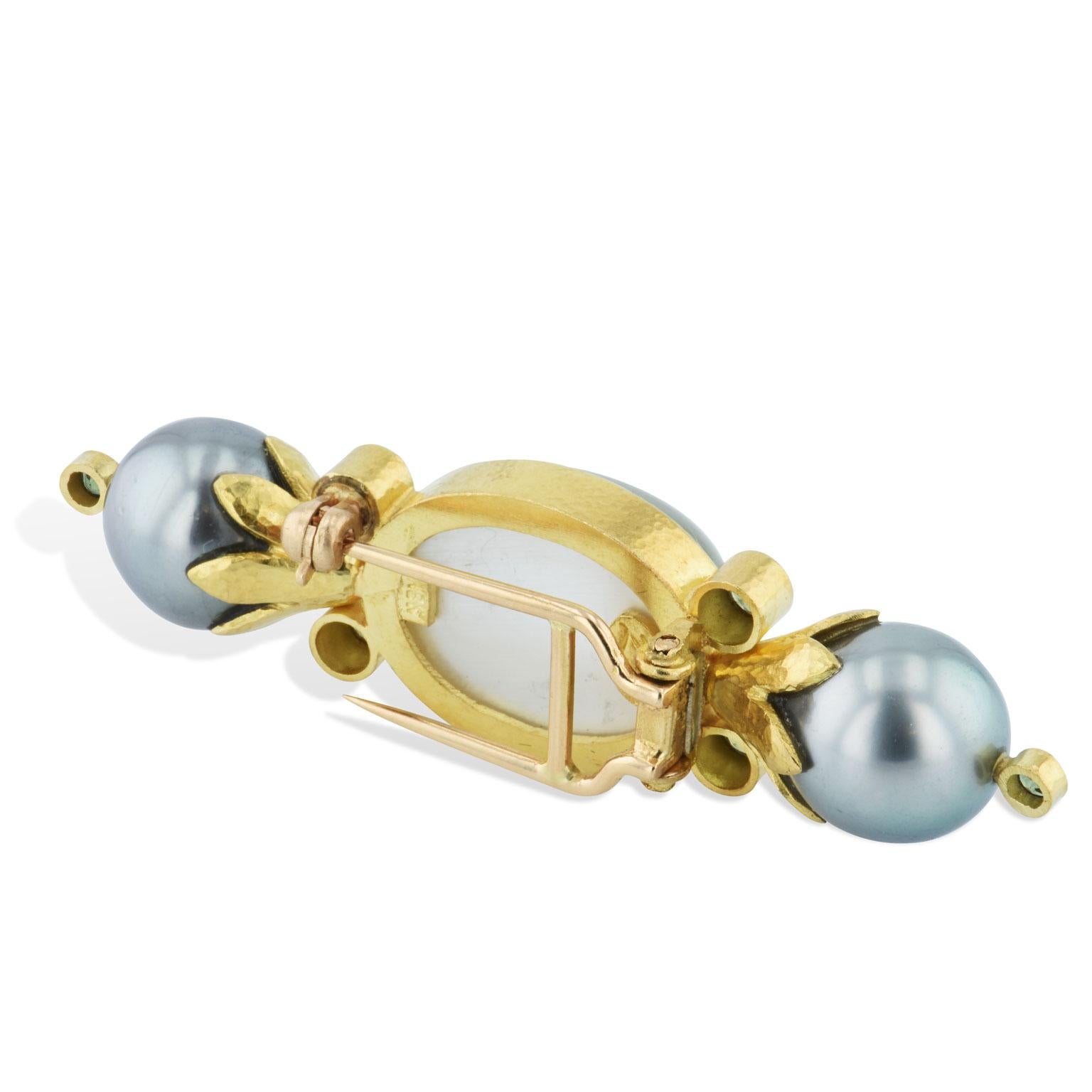 Feminine, strong and ethereal, this previously loved Elizabeth Locke 18 karat yellow gold pin features six green tourmaline punctuated between two Tahitian pearls and one green quartz. Backed in mother of pearl, this piece will live her breathless