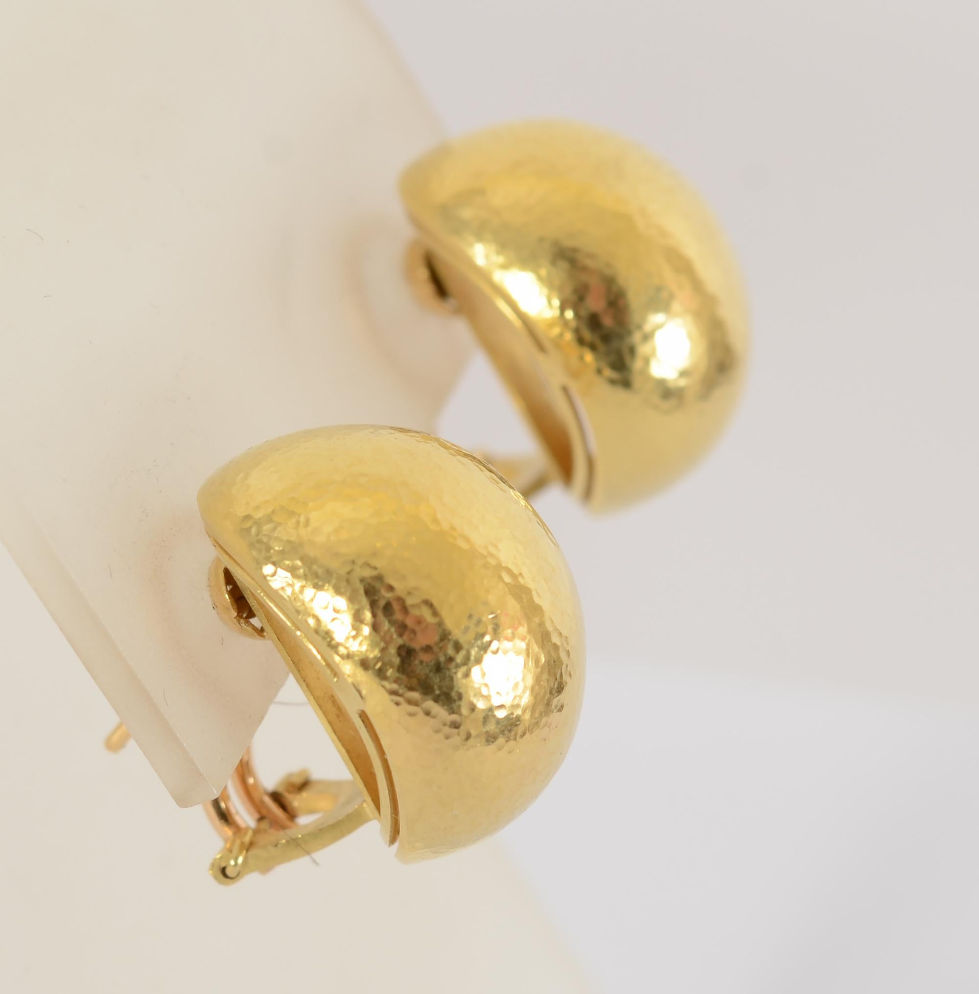 Elizabeth Locke gehämmerte goldene Garnelenohrringe mit bauchiger Form. Eine Öffnung entlang der Länge jeder Seite verleiht diesen Ohrringen, die sowohl zum Kleid als auch zur Freizeitkleidung passen, ein wenig Dekoration.
Die Rückseiten sind Clips