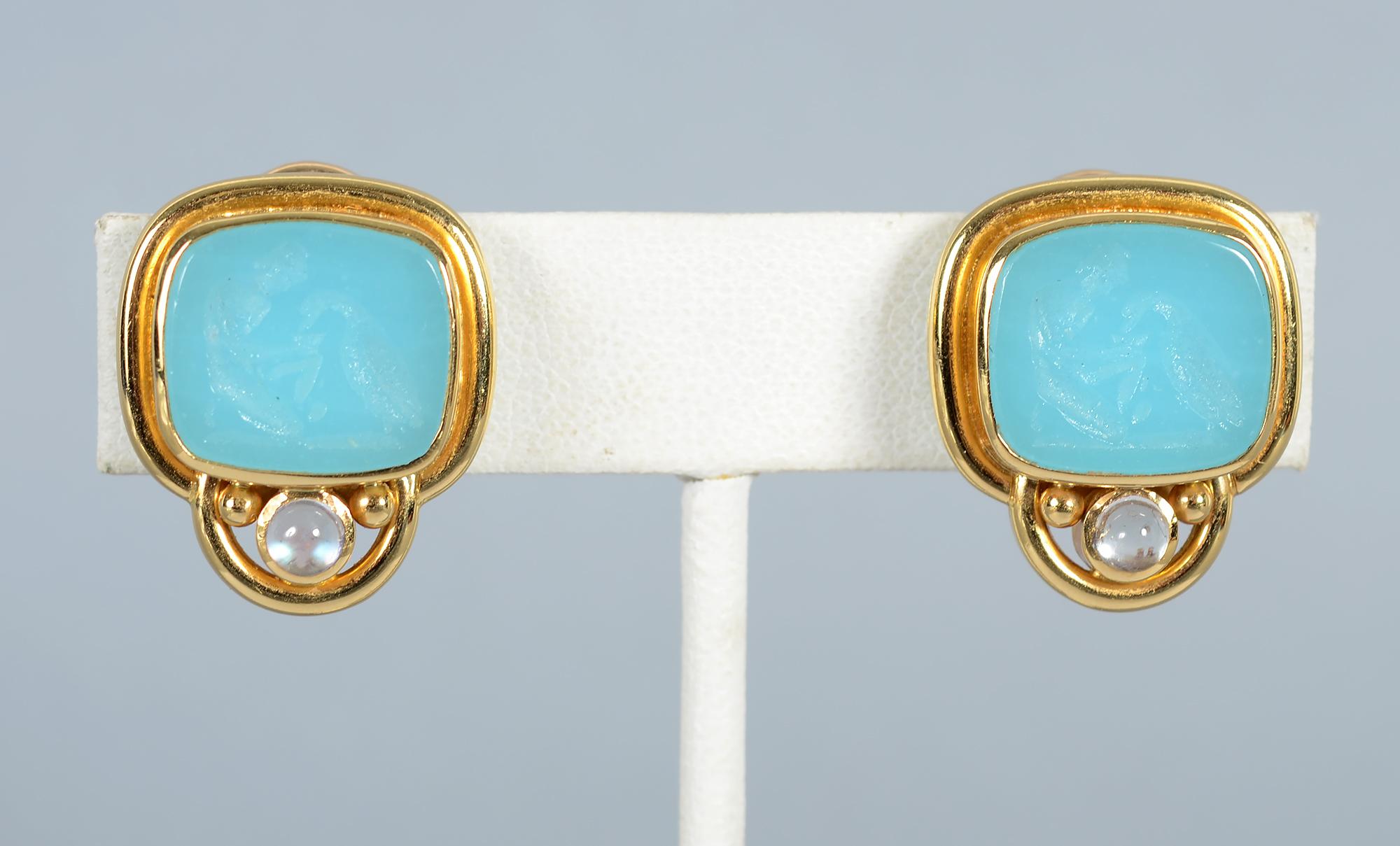 Elizabeth Locke glass intaglio earrings in a beautiful shade of seafoam blue. Below the body of the earring is a cabochon moonstone that reflects light to a similar blue color. The rectangular intaglio is surrounded by a collar bezel. The intaglio