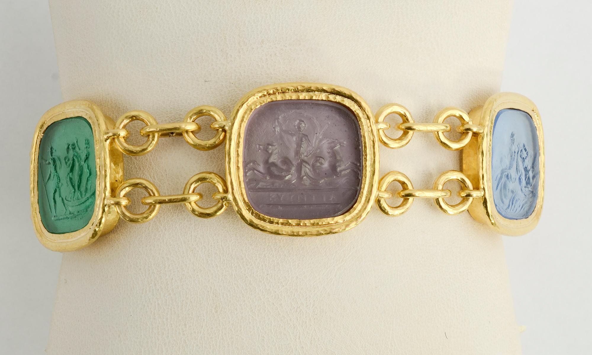 Elizabeth Locke intaglio bracelet depicting scenes of ancient life with humans and animals. The five Venetian glass medallions are beautifully color coordinated.
The bracelet has a wearable length of 7 7/8 inches. An additional medallion can be