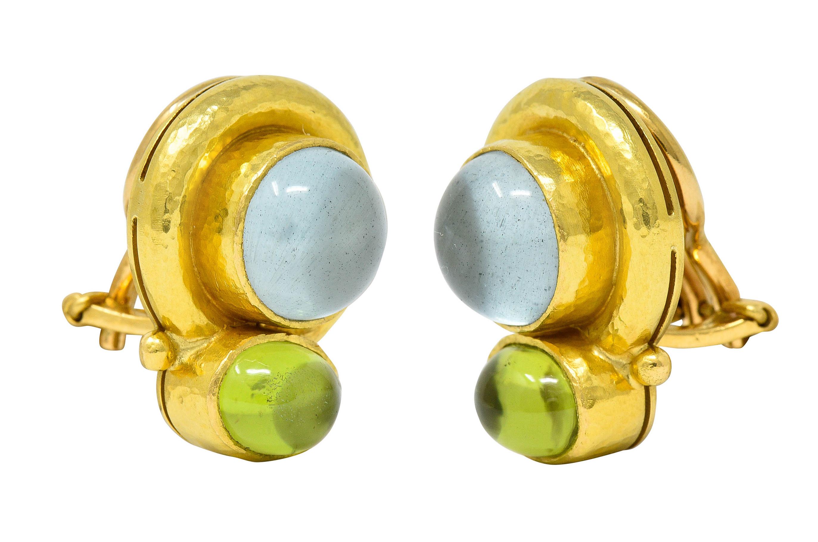 Earrings are designed as two gemstone cabochons - bezel set in hammered gold surrounds

Featuring 9.0 mm round labradorite backed by white mother-of-pearl

Semi-transparent and light gray in color with a billowing white sheen

With oval peridot