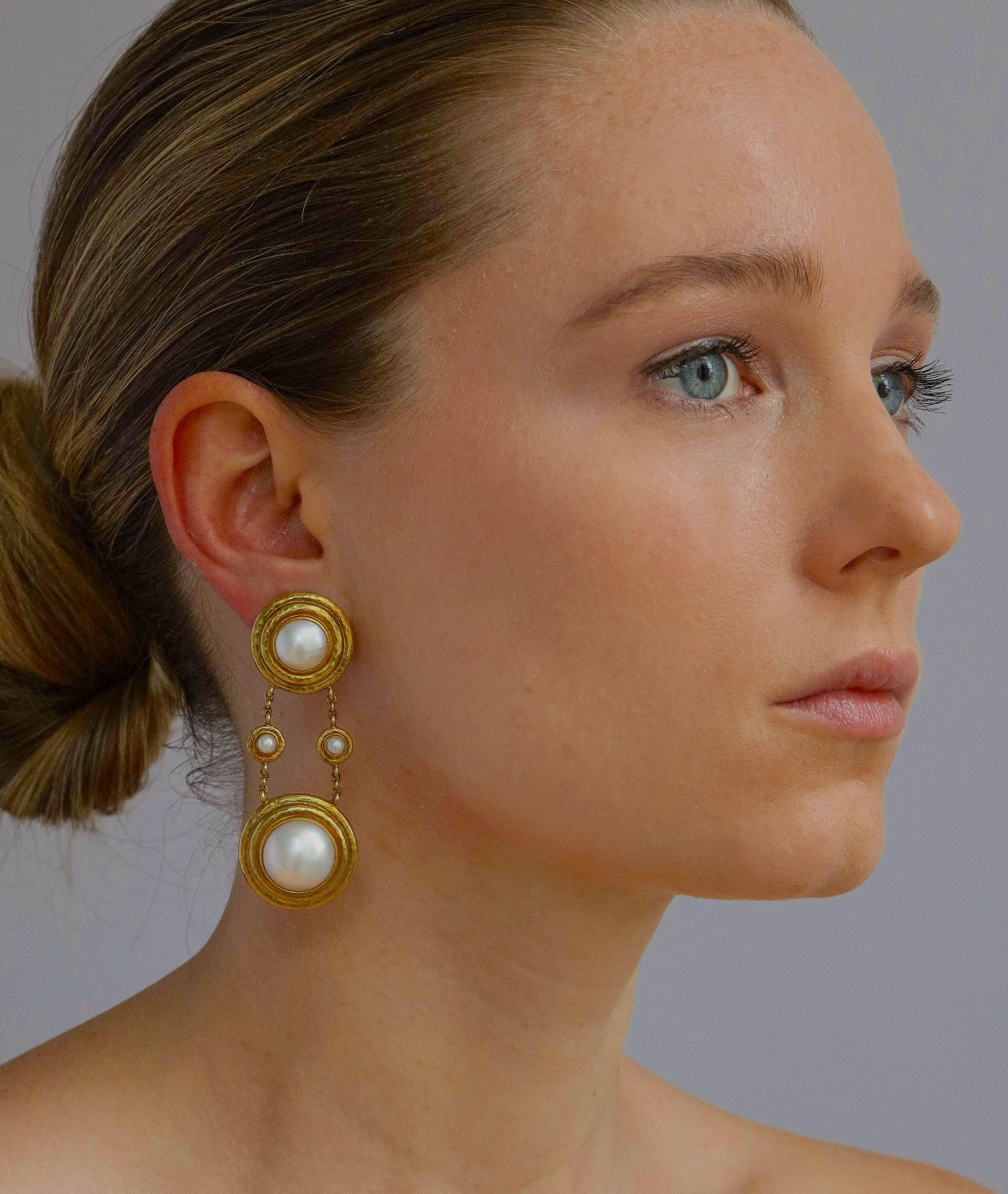 Elegant and fashionably long Elizabeth Locke ear clips of 18K gold set with lustrous mabe pearls both youthful and sophisticated with a hinged post for an added pierced option. The top pearl measuring 3/4 inch diameter and the lower 1 inch with a