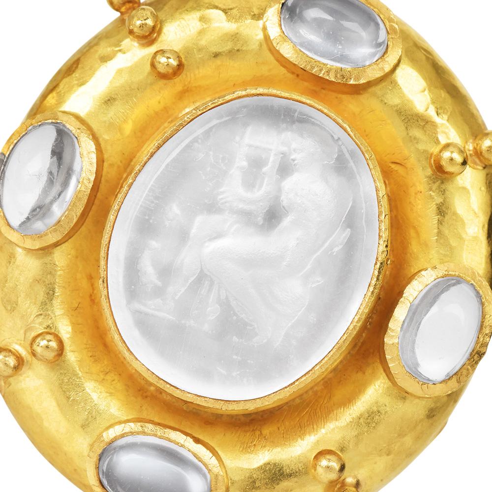Gli orecchini a lobo firmati Elizabeth Locke sono un'accattivante miscela di arte classica ed eleganza moderna. Realizzati in lussuoso oro giallo 18 carati, questi squisiti orecchini presentano un'incisione unica di una donna che suona una lira,