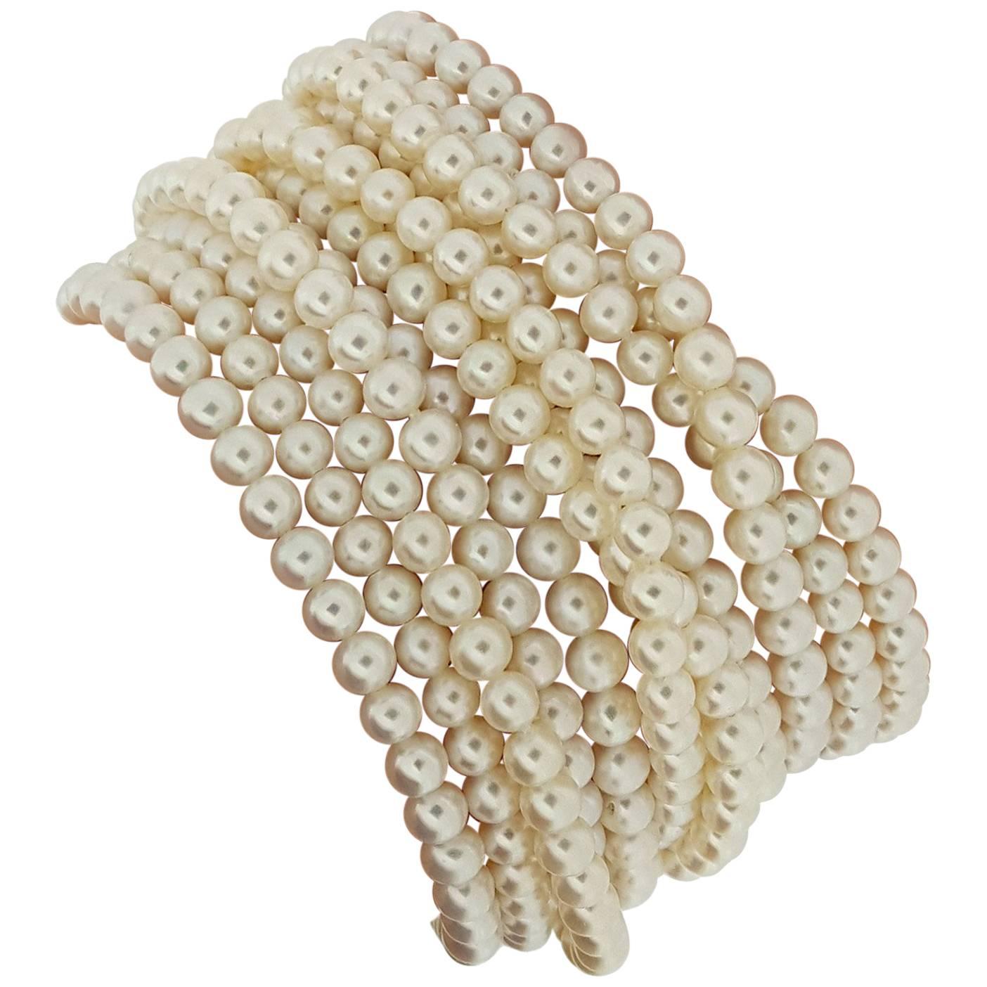 This incredible pearl bracelet designed and signed by Elizabeth Locke features 12 individual strands of pearls measuring approximately 4.5mm. The bracelet is 7.25 inches long and secured with a handmade 18kt yellow gold hammered clasp with beaded