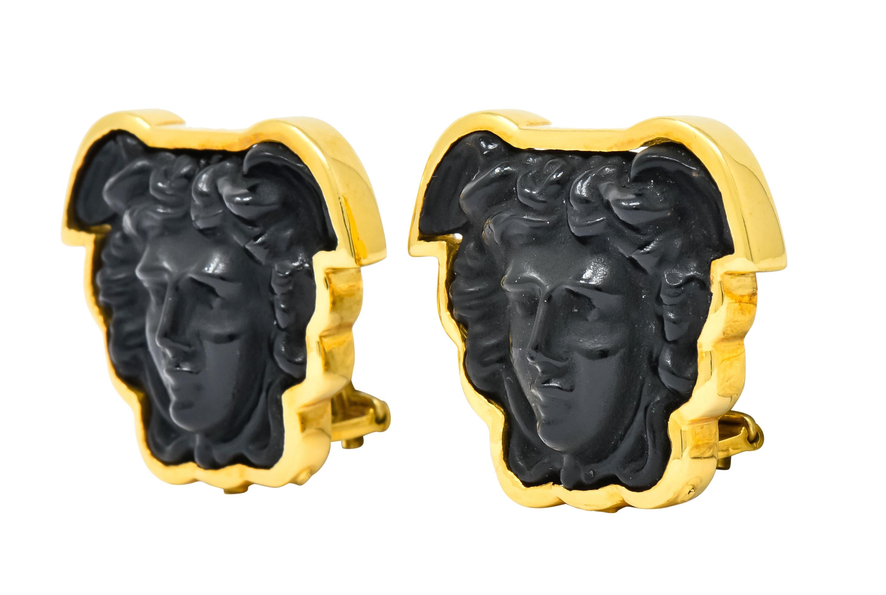Each earring centers carved onyx depicting a detailed rendering of Medusa

Bezel set in a polished gold surround

Completed by hinged omega backs with optional posts

With maker's mark for Elizabeth Locke and stamped 18k for 18 karat gold

Measures: