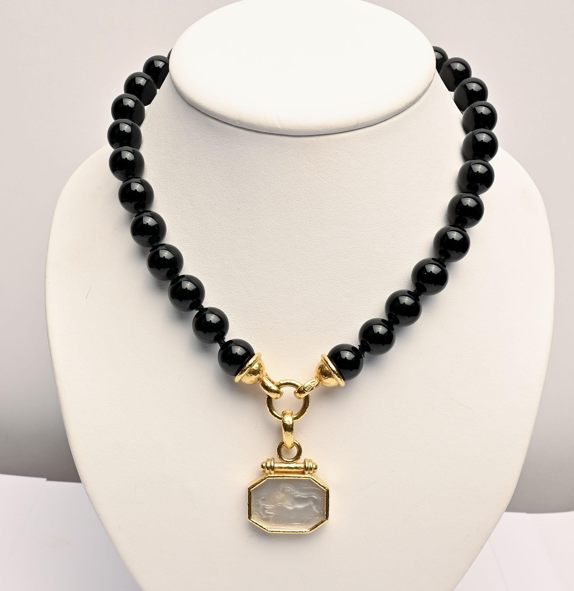 Stunning necklace of round black onyx beads by Elizabeth Locke. The beads are 12 mm in size. The necklace can be worn as a 17 inch single strand of beads or with a pendant attached. It comes with an octagonal shape glass pendant of a seated angel