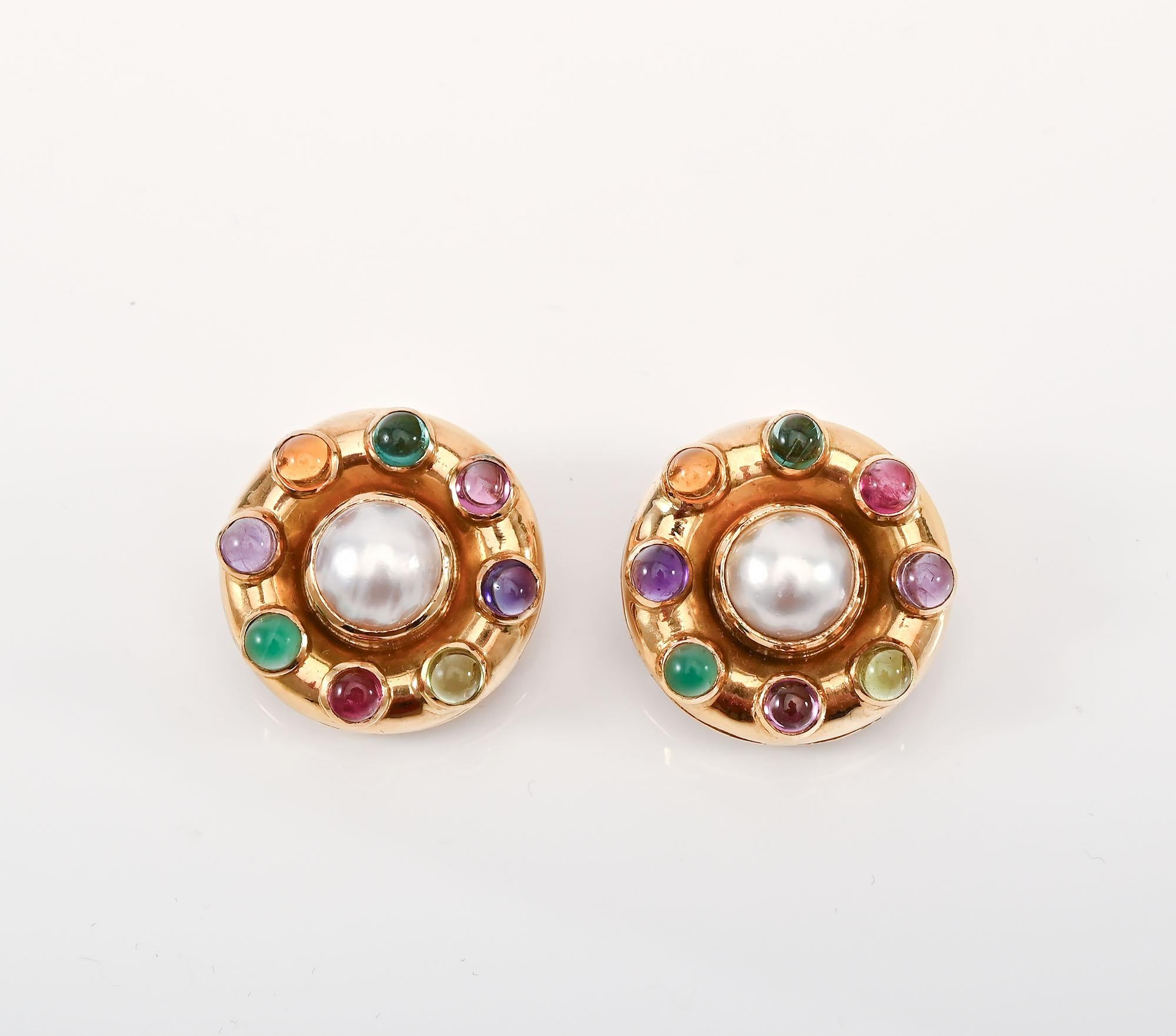 Elizabeth Locke multicolor earrings centered with an 11 mm pearl. Surrounding each pearl are 8 cabochon stones that include tourmaline; amethyst and blue topaz. The backs are clips with a collapsible post as Locke features on all of her earrings.