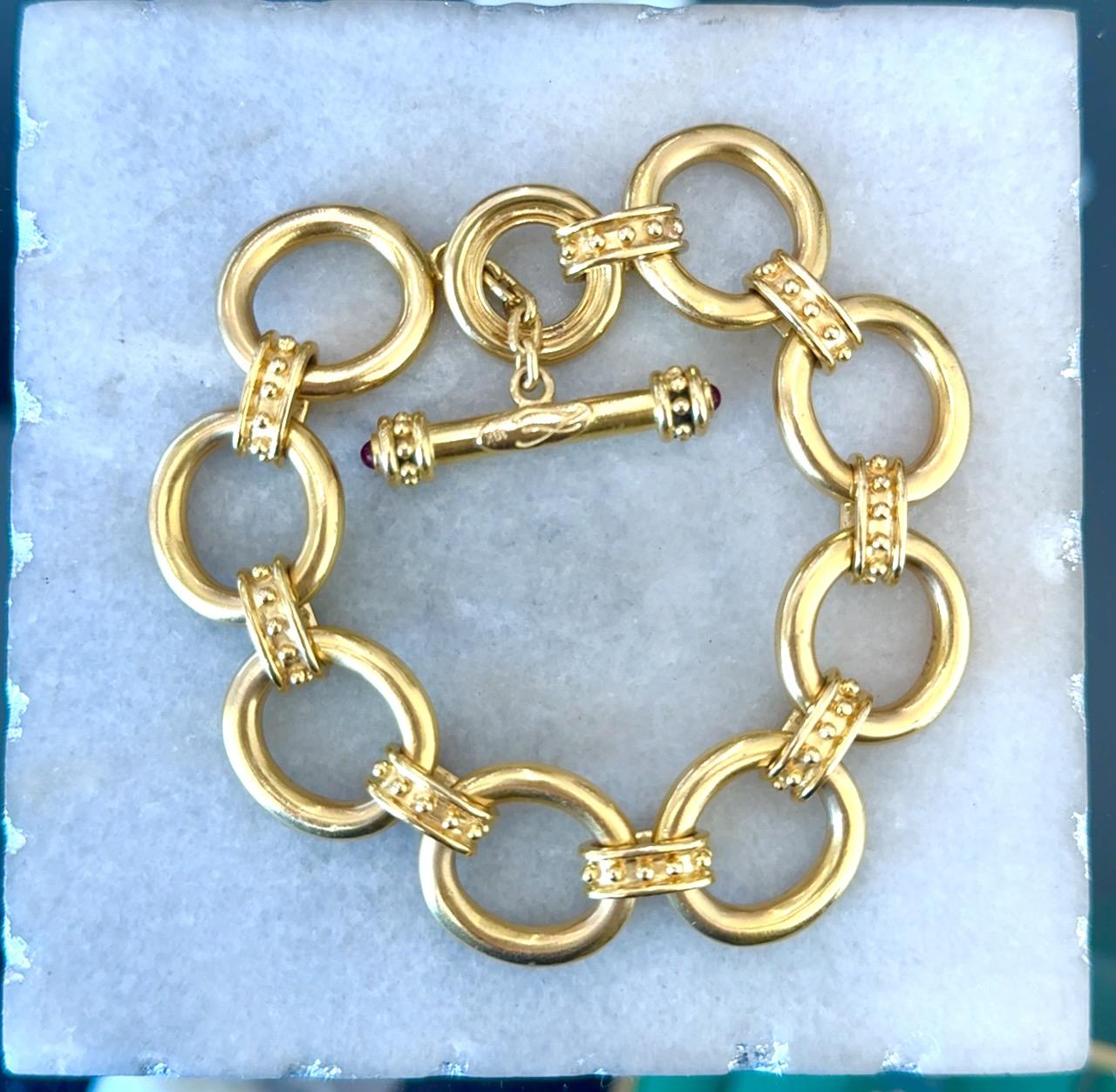 Elizabeth Locke - Bracelet en chaîne à maillons basculants
52,7 grammes d'or jaune 18kt
2 rubis cabochon sur la poignée
19 mm de large
Convient à un poignet de 6,5-7 pouces
8,5 pouces de long
Au début des années 2000
Le bracelet est en très bon