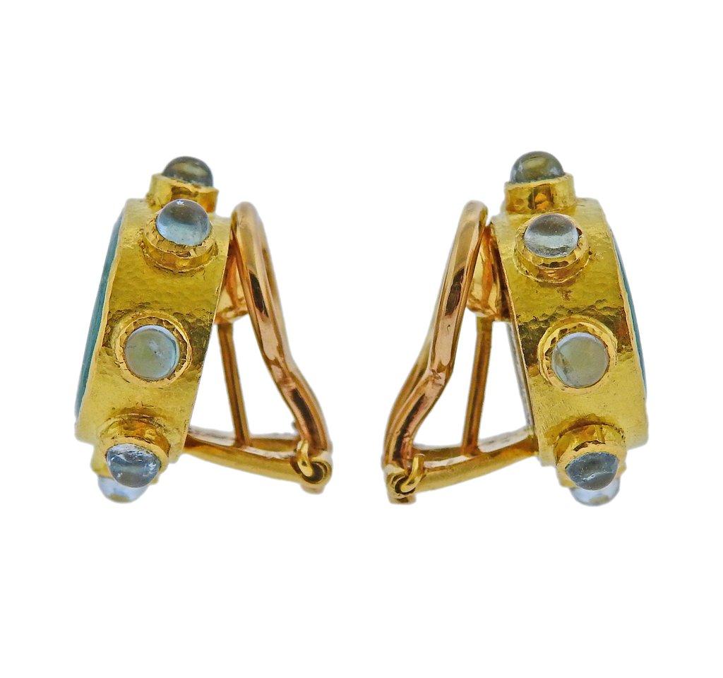 19k yellow gold earrings by Elizabeth Locke, featuring light blue Venetian glass intaglio, backed with mother of pearl, surrounded with aquamarine cabochons.  Earrings are 20mm x 23mm, collapsible posts. Weight is 16.2 grams. Marked 19k, E hallmark. 