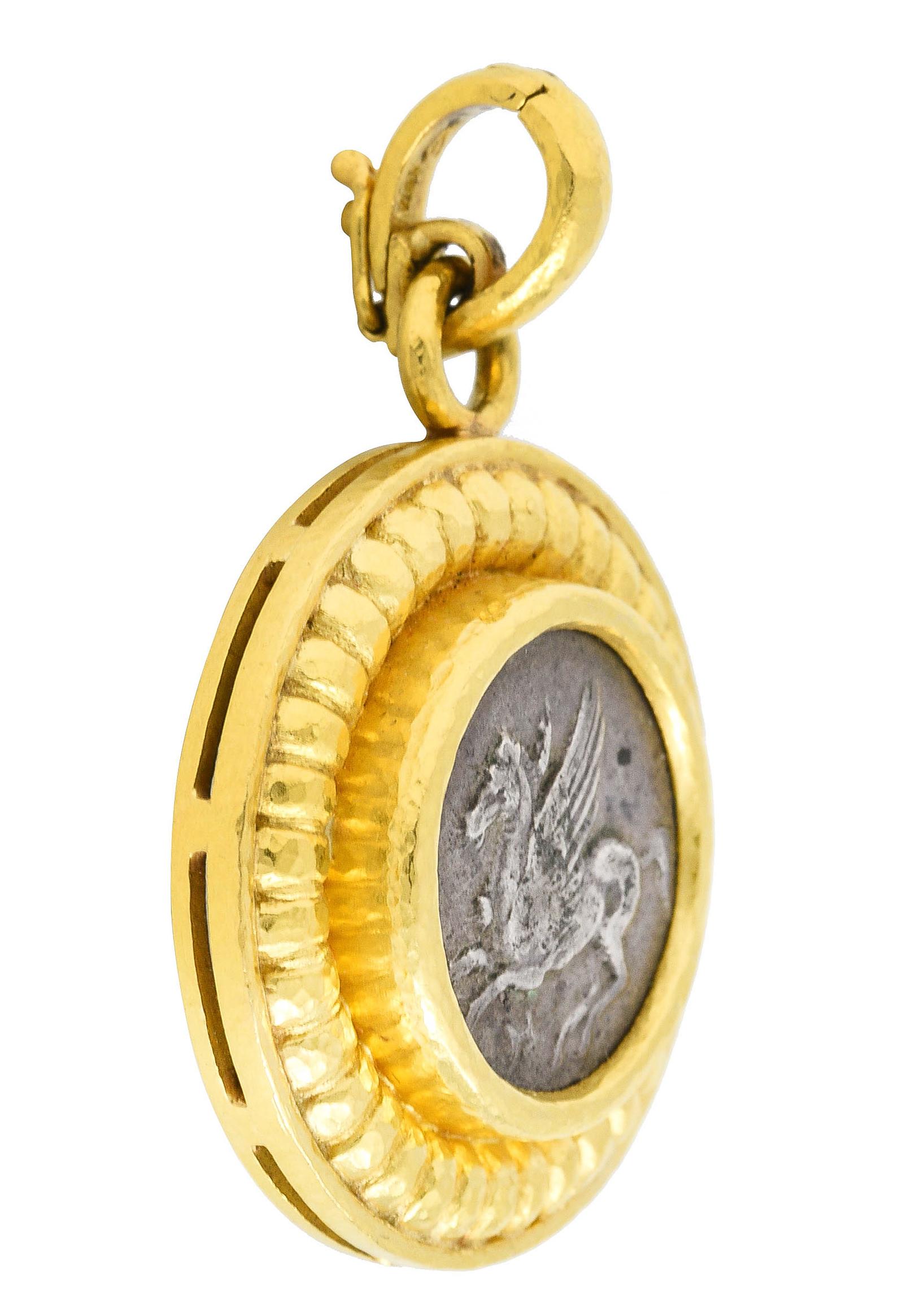 Pendant is designed as a round form centering an ancient style coin with a cameo of a pegasus

Reverse depicts a cameo of the Greek goddess Athena in profile wearing a helmet

Featuring a deeply grooved hammered gold frame surround

Completed by an