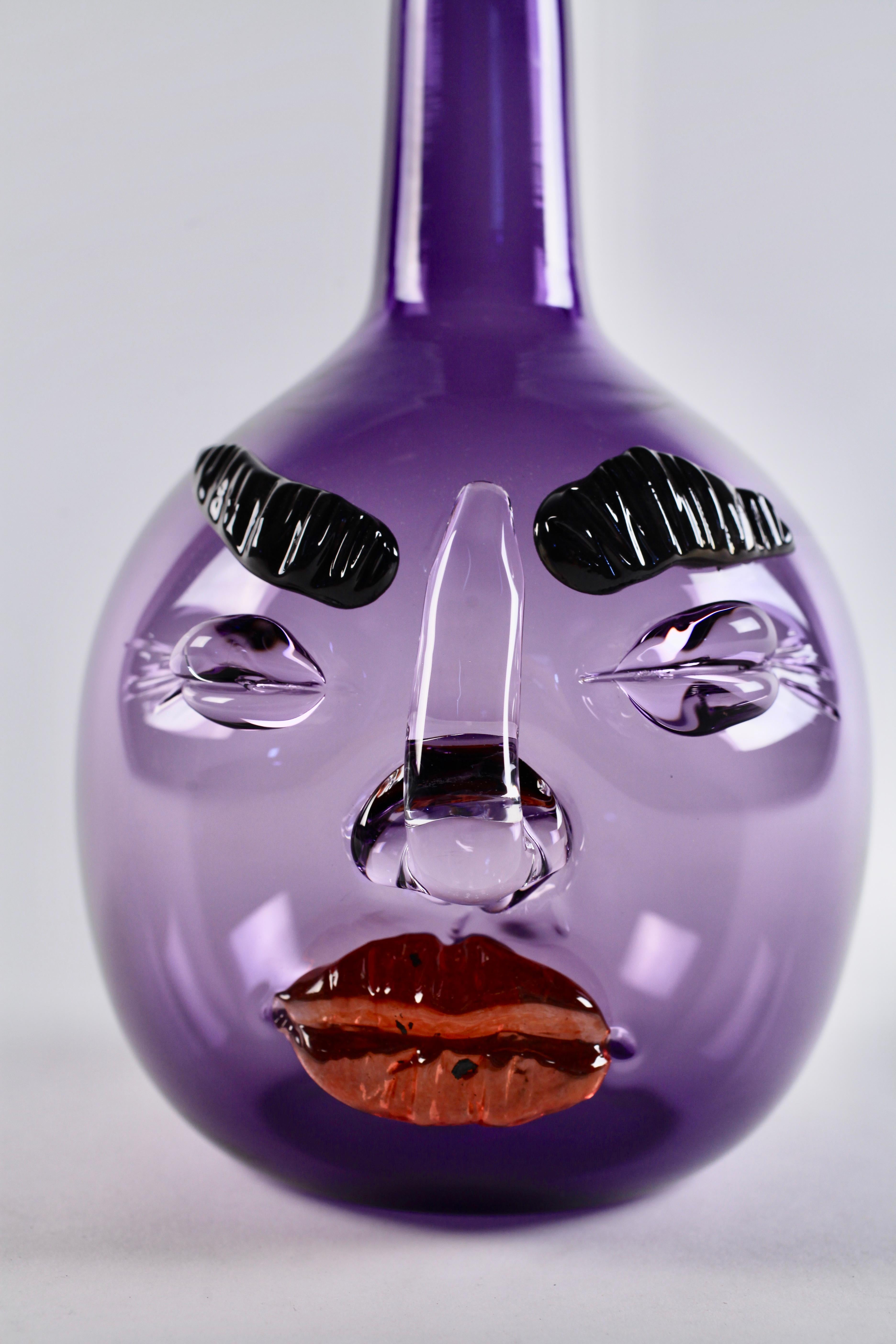 Hand blown and hot sculpted glass, this purple Bottle-head vessel by Elizabeth Lyons is both playful and sophisticated, blooming with a personality all its own. Elizabeth makes these sculptural hand blown bottles in her Rochester, NY studio. Their