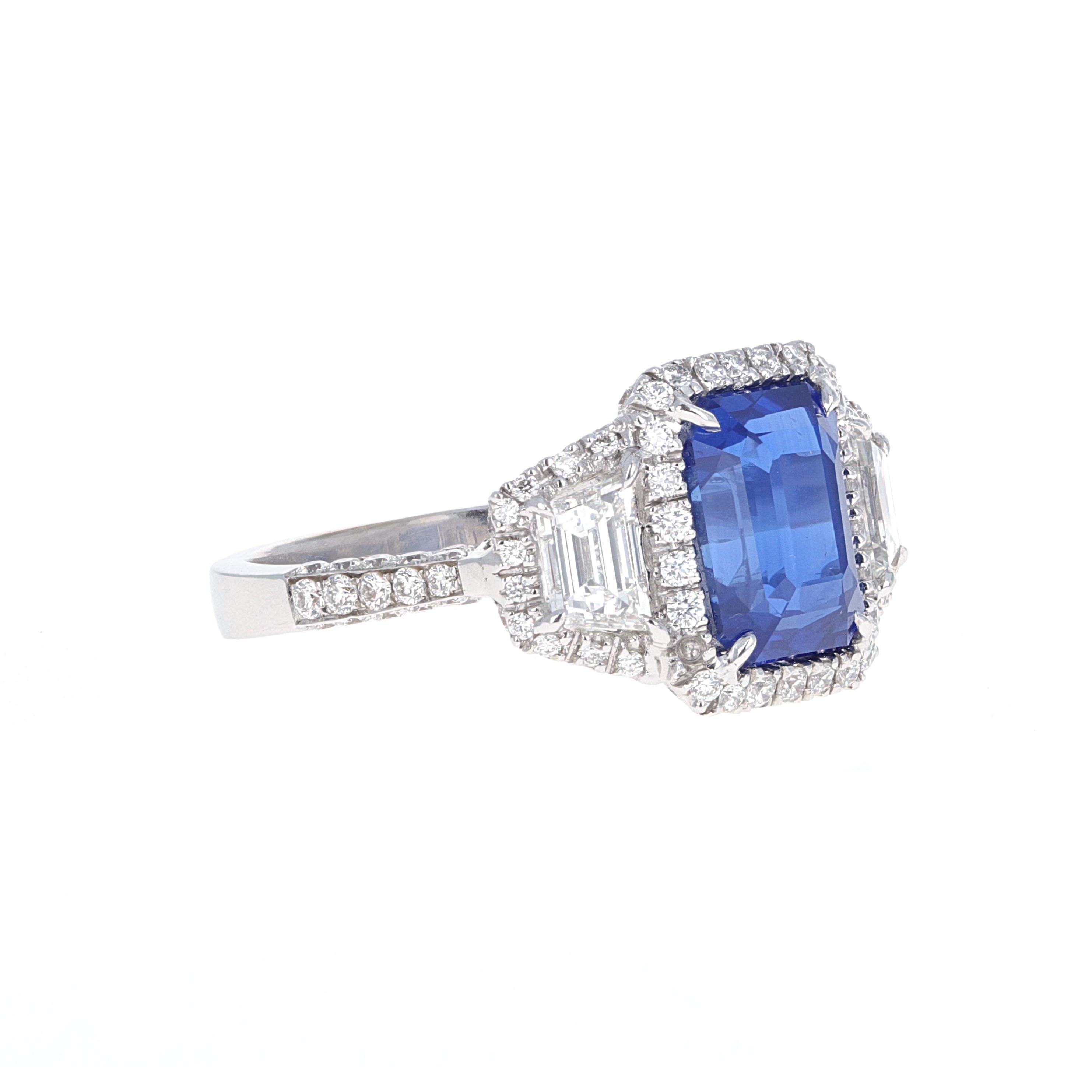 Handmade beautiful blue emerald cut sapphire three-stone diamond ring by Elizabeth Taylor Collection, House of Taylor. The blue sapphire is an emerald cut weighing 4.50 carats. The House of Taylor ring has 2 Trapezoid diamonds, one on each side of
