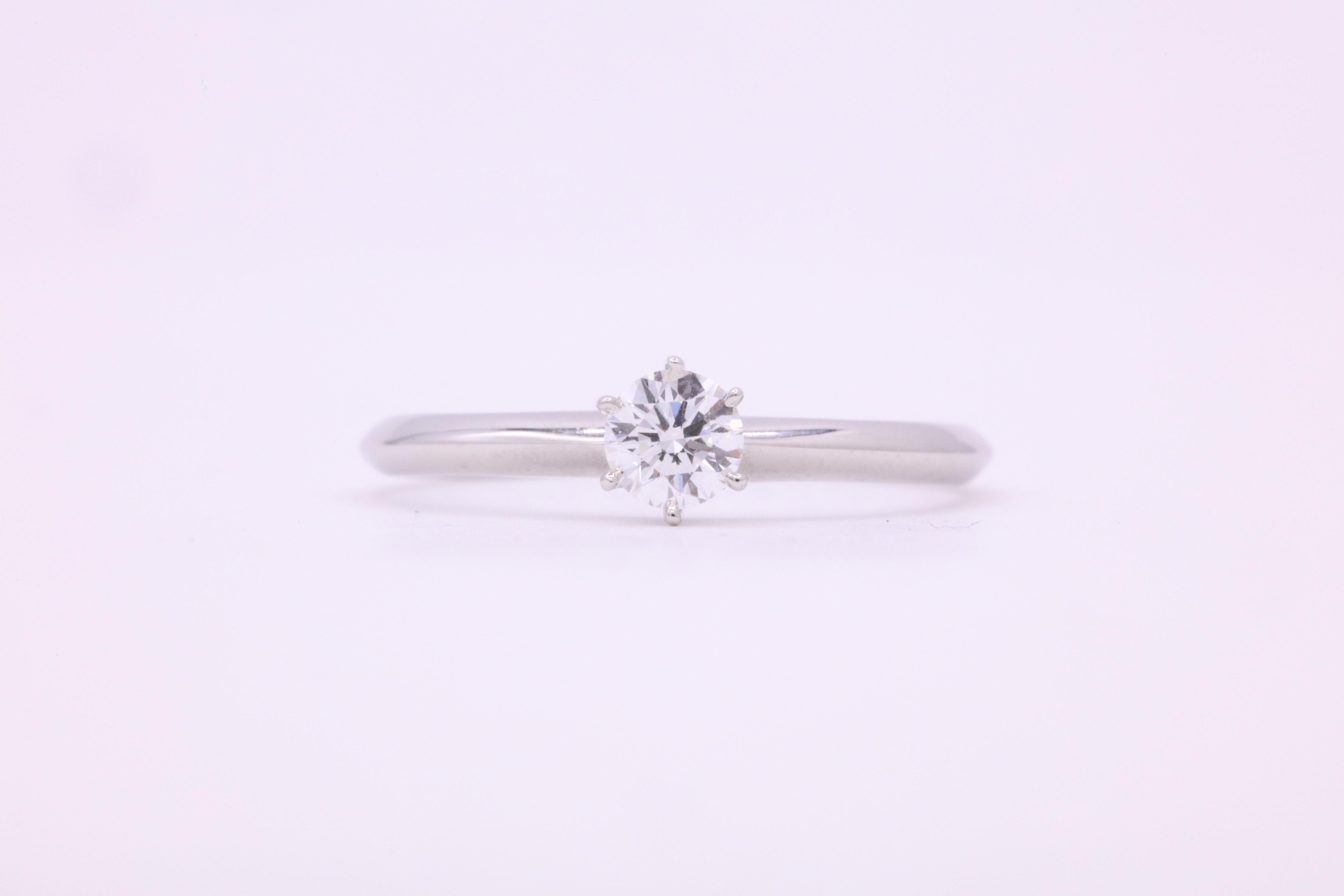 Tiffany & Co, anillo de compromiso solitario de diamantes con un brillante redondo de 0,21 quilates en un engaste de 6 garras, elaborado en platino. 
Color F
Claridad VVS2
Viene con una caja de Tiffany & Co. Certificado. 
