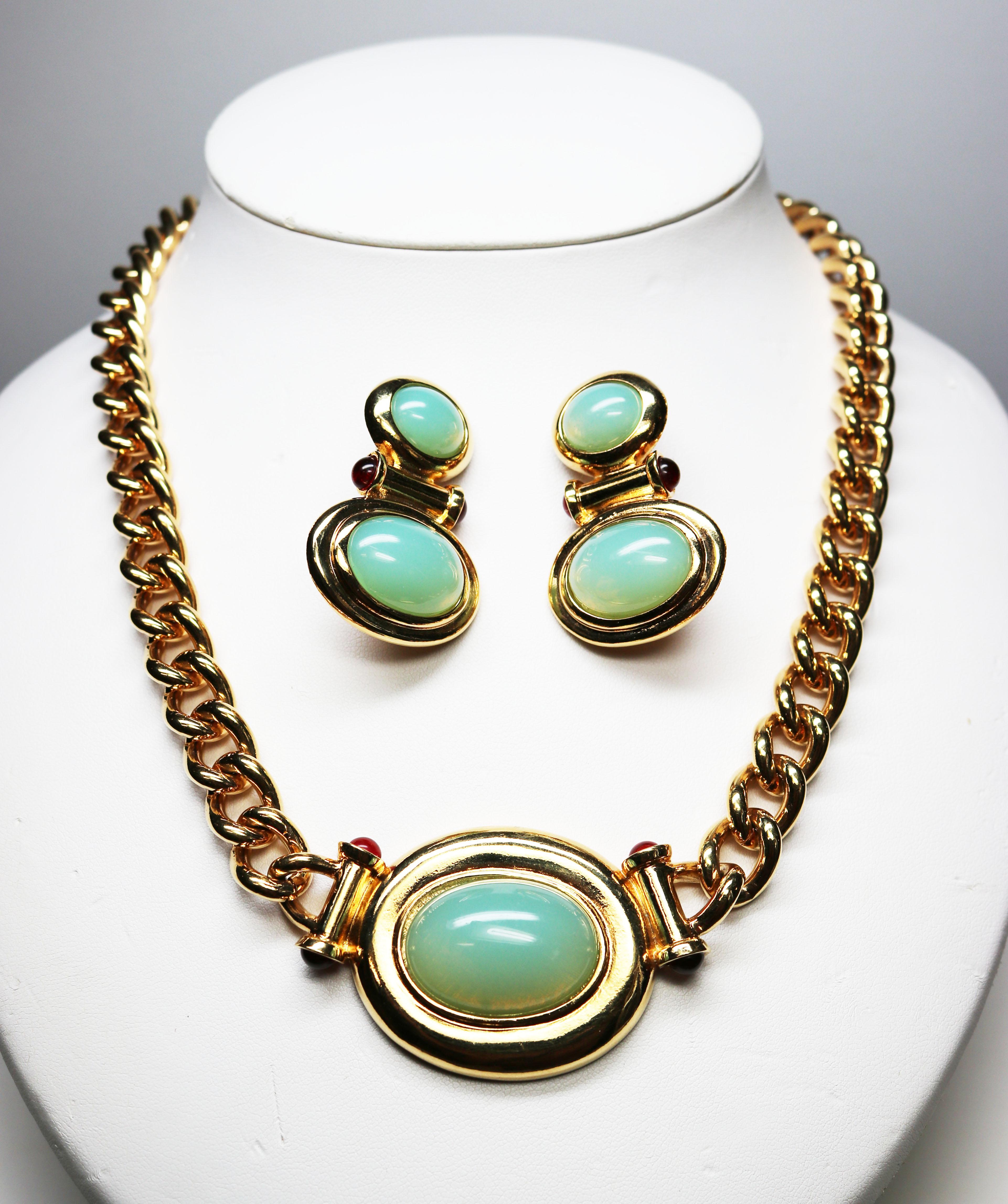 This beautiful Elizabeth Taylor for Avon Demi parure features simulated Peking glass cabochons, which resemble large opals. The gorgeous, golden, chunky chain is New York City style with golden columns and simulated ruby cabochons framing the