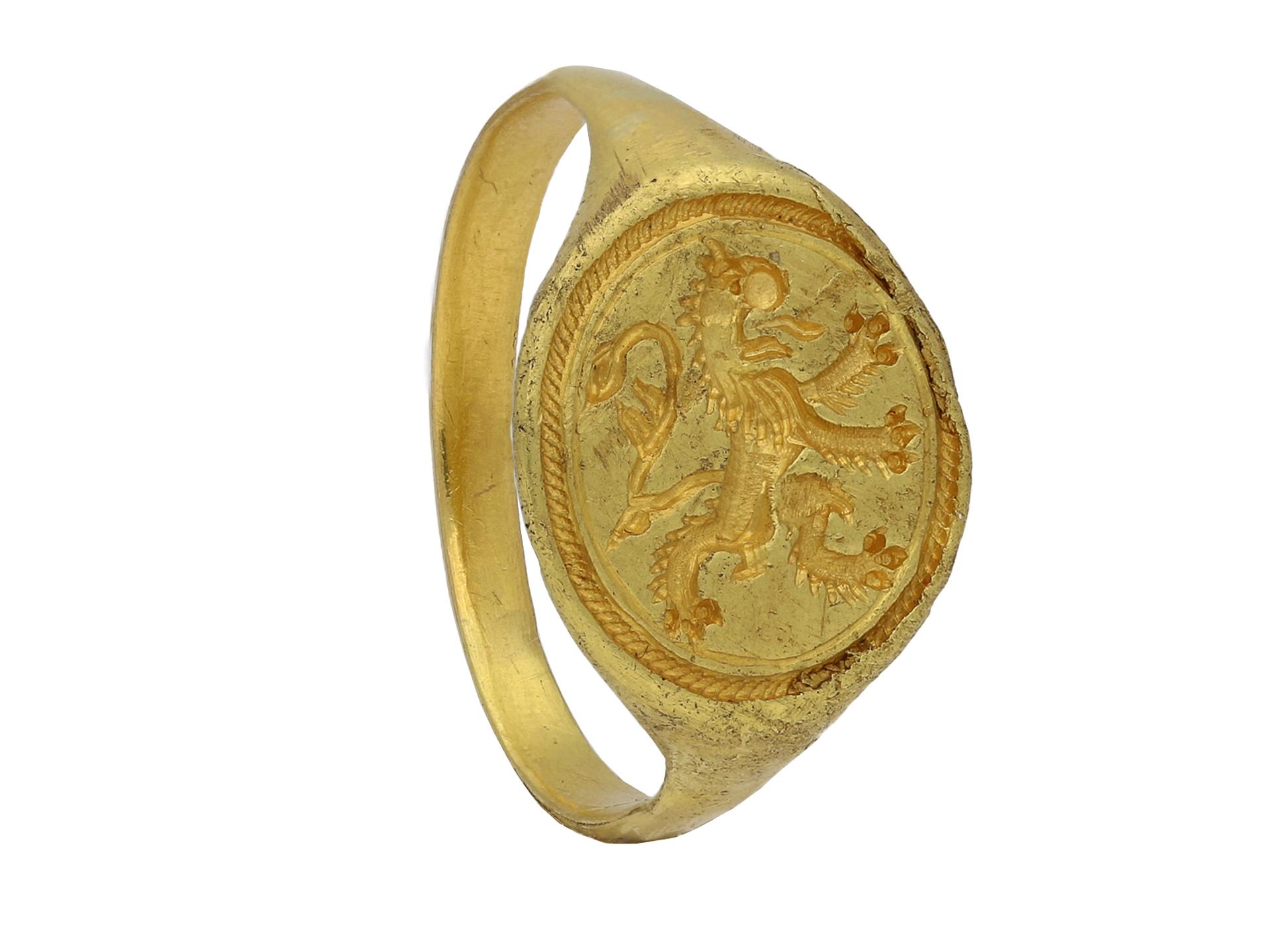Elizabethan gold signet ring with Scottish rampant lion. A solid gold signet ring comprising of a central flat discoid bezel with a ropework border, featuring a rampant heraldic lion facing to the left with jaws open and tongue extended, flanked by