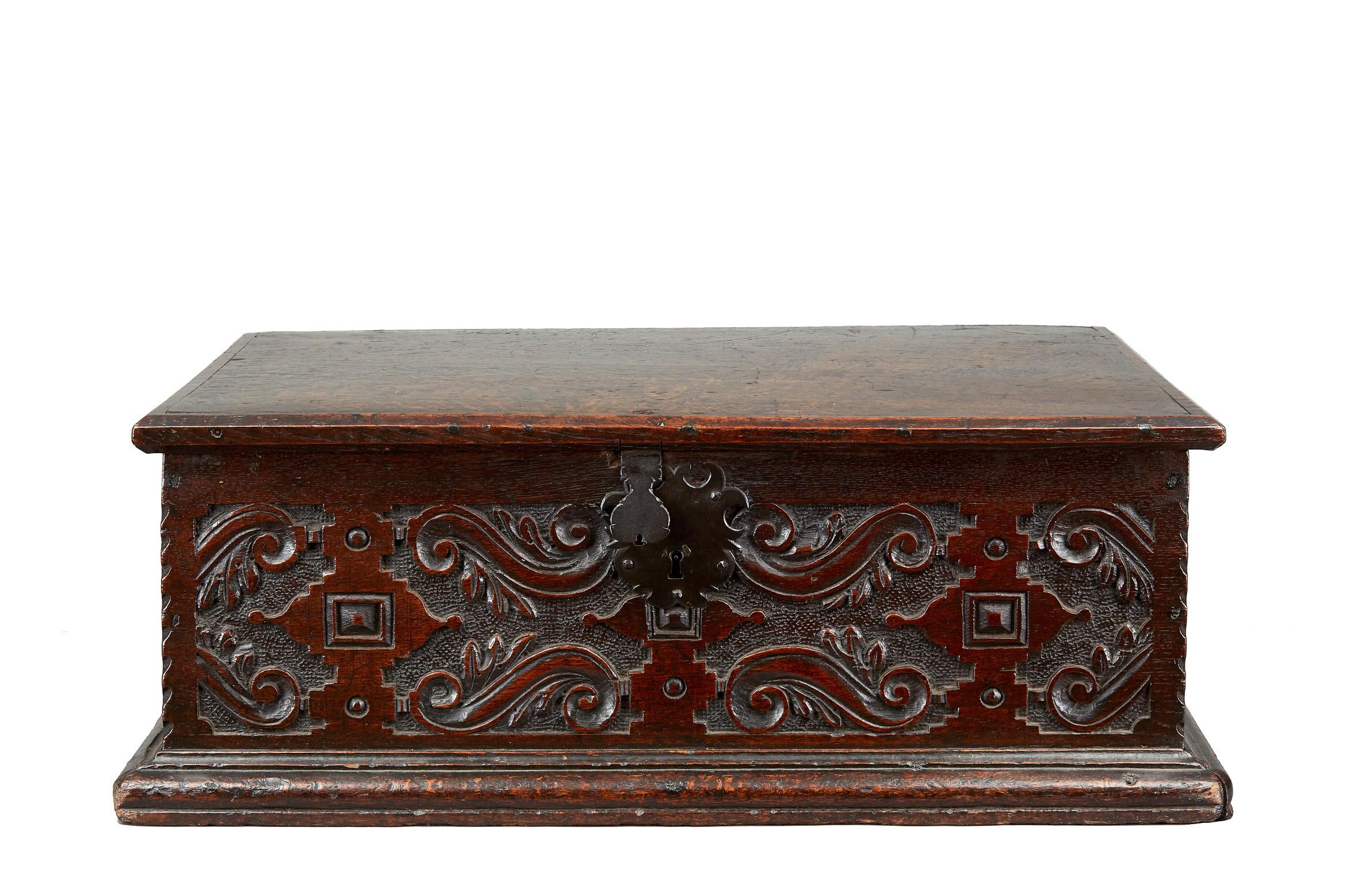 Late Elizabethan / James I oak document box, English, circa 1600-1620.

The highly figured single plank framed lid above a boarded box finely carved to three sides with geometric, foliate arabesque work, the front panel centred on an elaborate