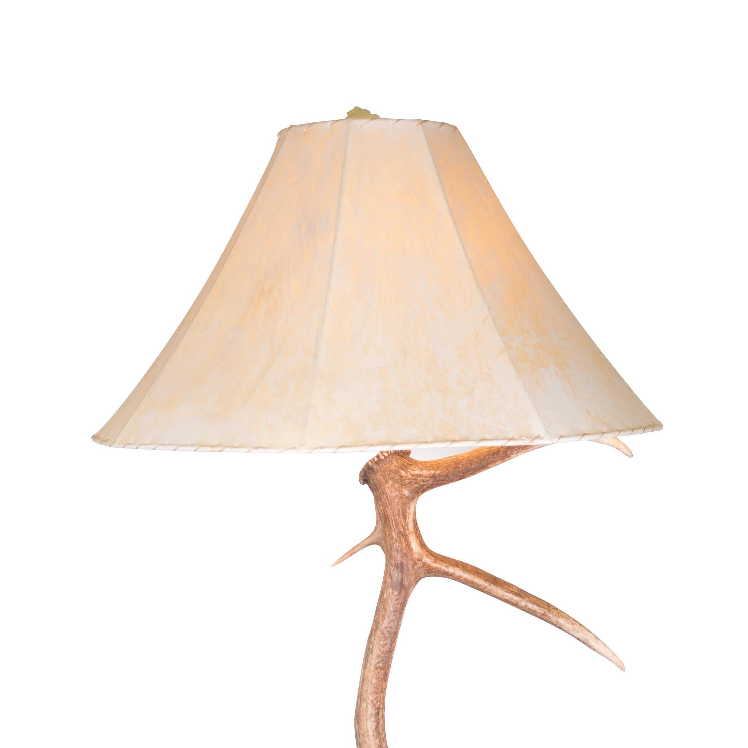 Elk and moose antler floor lamp of elk with moose base and rawhide shade having antler finial. 70