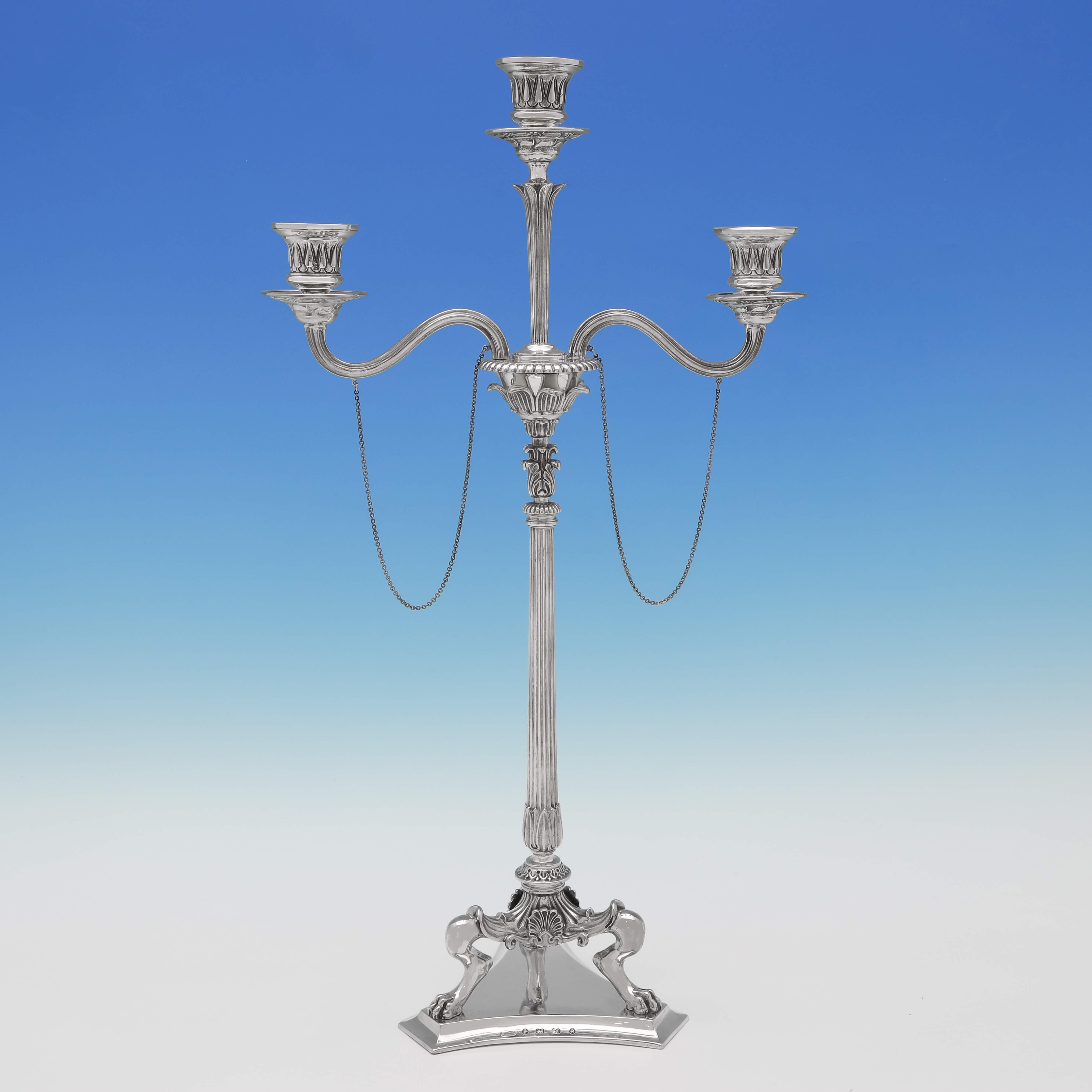 Hallmarked in Birmingham in 1867 by Elkington & Co., this attractive pair of Victorian, antique sterling silver candelabra, are in the Neoclassical Revival style, and hold three candles. Each candelabrum measures 20.25