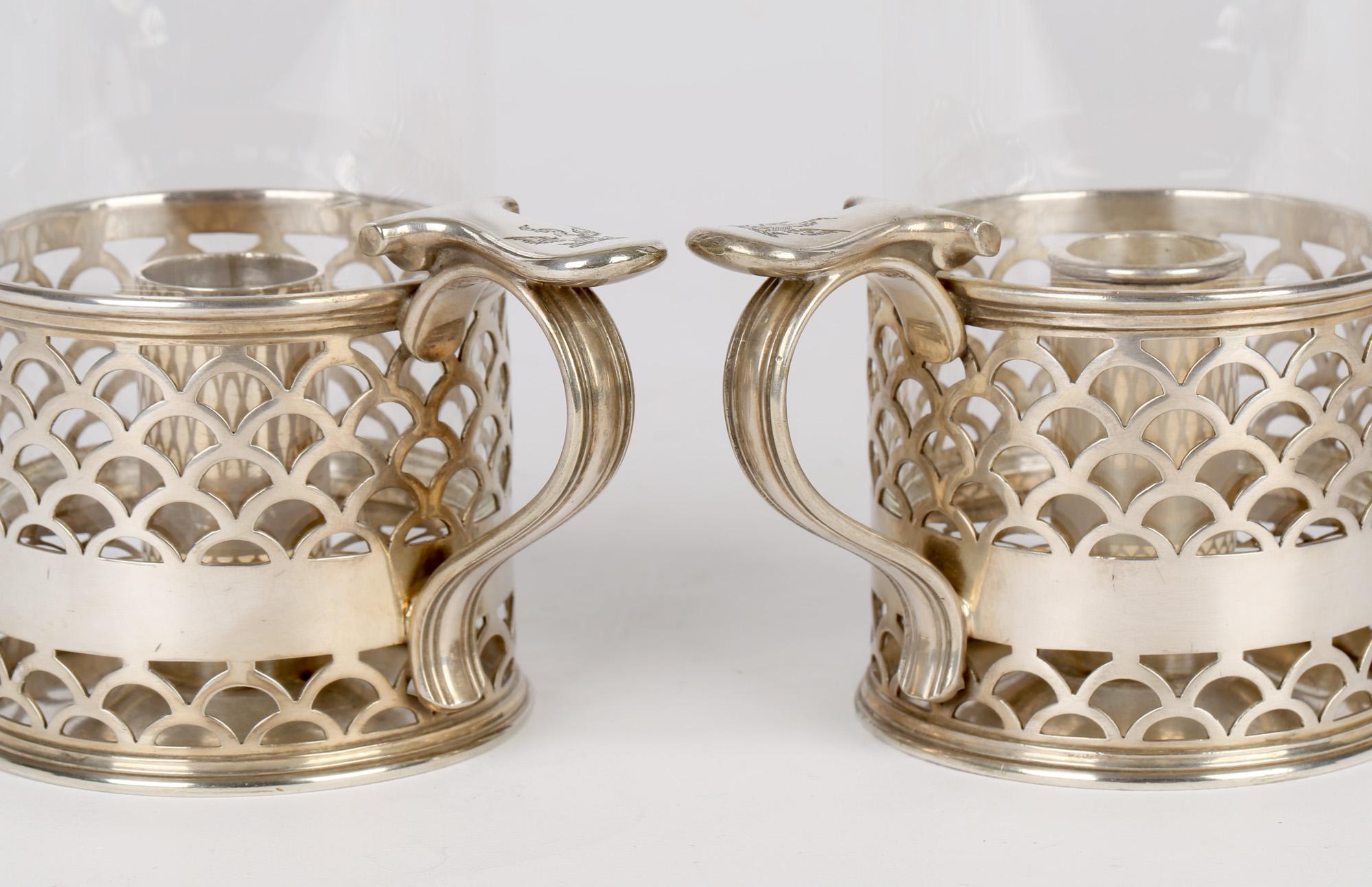 An exceptional quality pair antique Elkington & Co silver plated crested and glass storm lamp lanterns dated 1888. The lamps have a heavily made base with a carrying handle with a flat topped thumb rest each engraved with a crest showing an eagle on