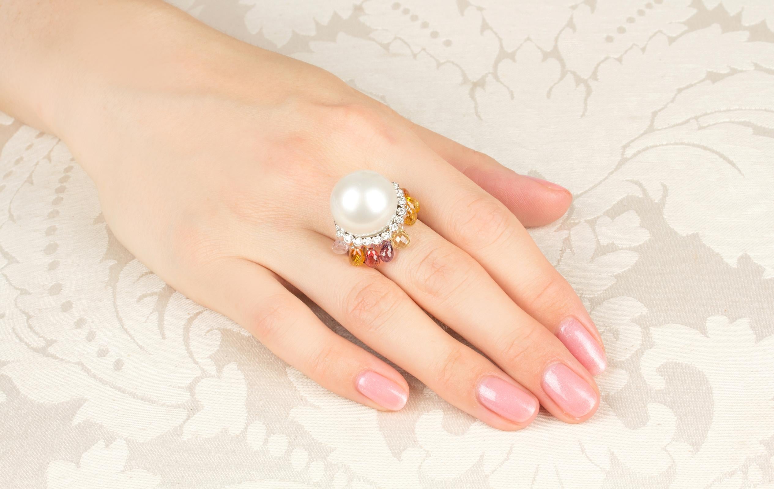 This unusual South Sea pearl and diamond cocktail ring features a splendid pearl of 17mm diameter. The pearl is untreated. It displays a fine nacre and its natural color and luster have not been enhanced in any way. The pearl is perched on a crown