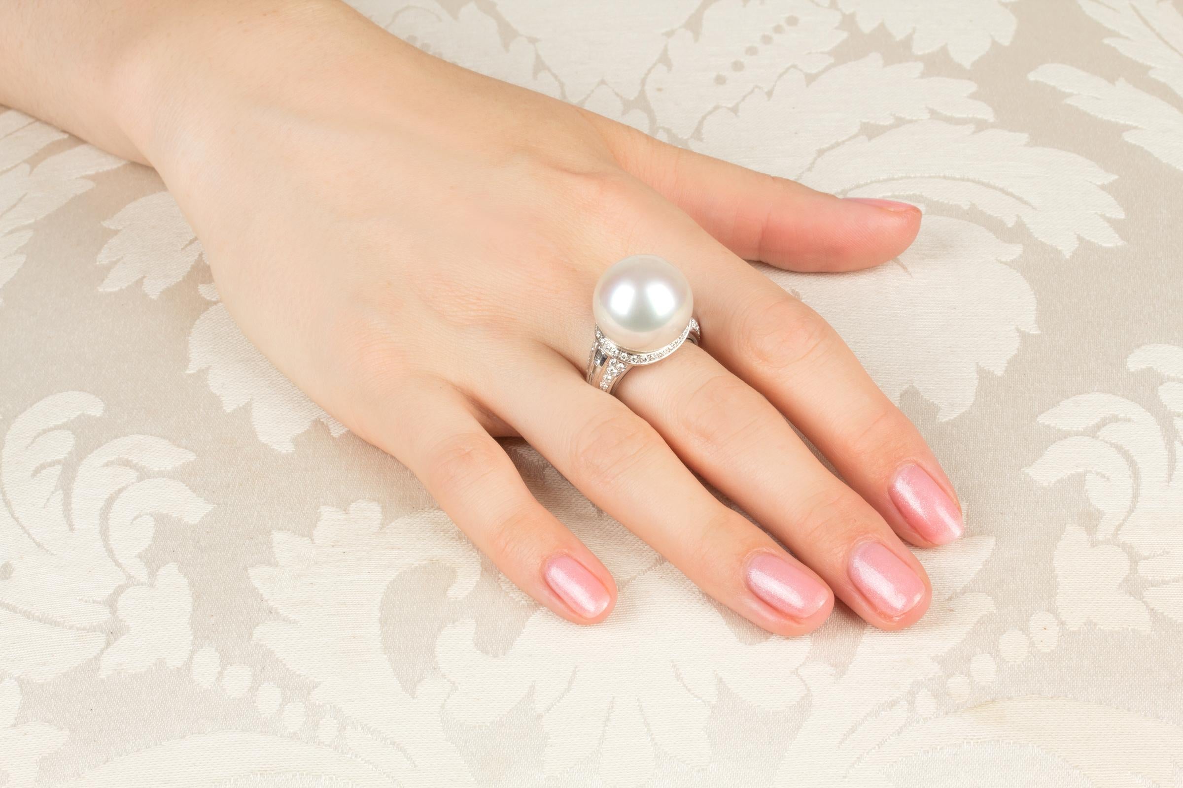 This South Sea pearl and diamond cocktail ring features a large pearl of 18mm diameter. The pearl is untreated. It displays a splendid nacre and its natural color and luster have not been enhanced in any way. The pearl is perched on a crown of round
