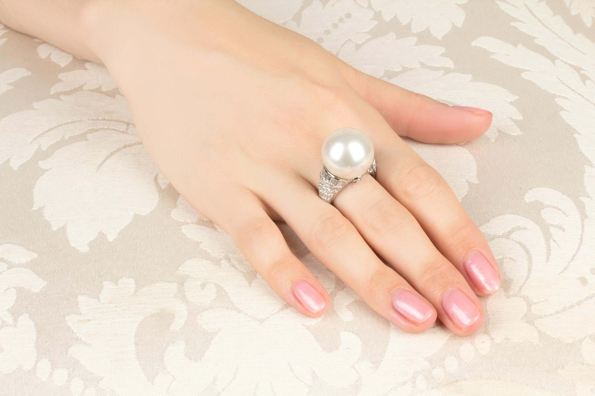 This South Sea pearl and diamond cocktail ring features a voluminous gem quality pearl of 18mm diameter. The pearl is untreated. It displays a fine nacre and its natural color and luster have not been enhanced in any way. The pearl is flanked by