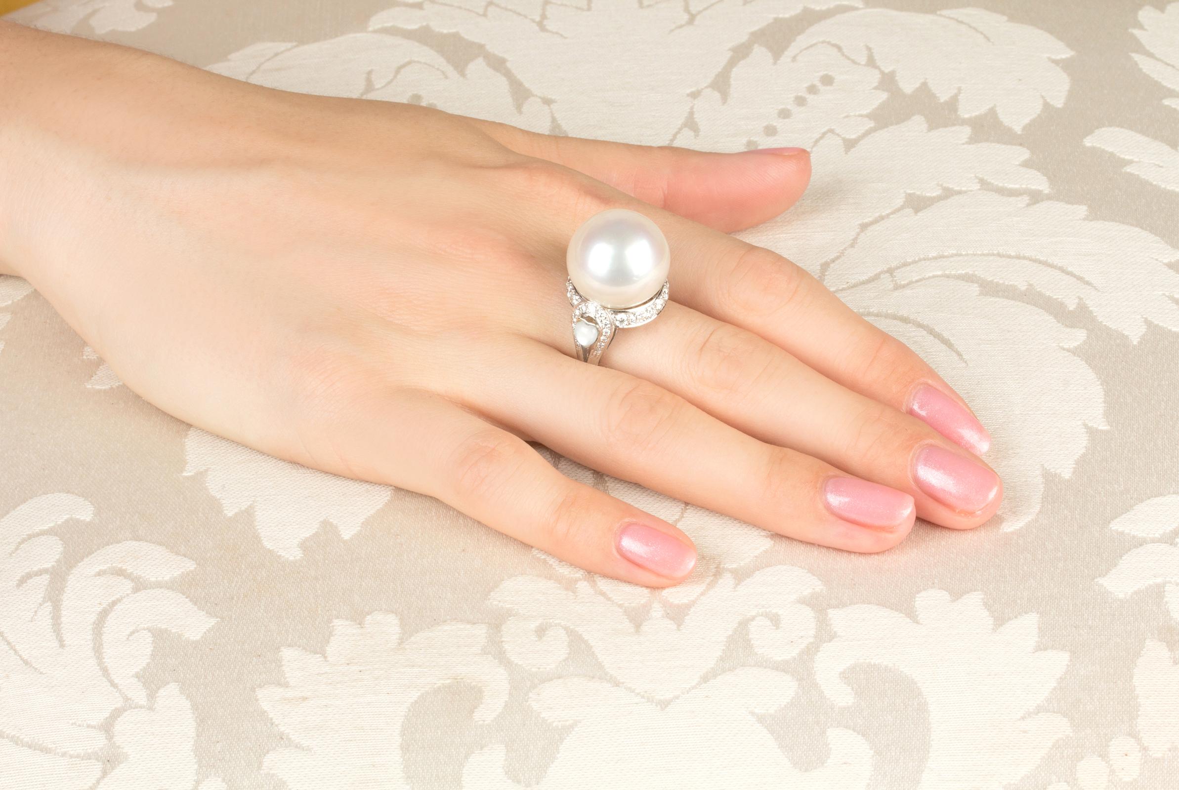 This South Sea pearl and diamond cocktail ring features a splendid Australian pearl of 18mm diameter. The pearl is untreated. It displays a fine quality nacre and its natural color and luster have not been enhanced in any way. The pearl is perched