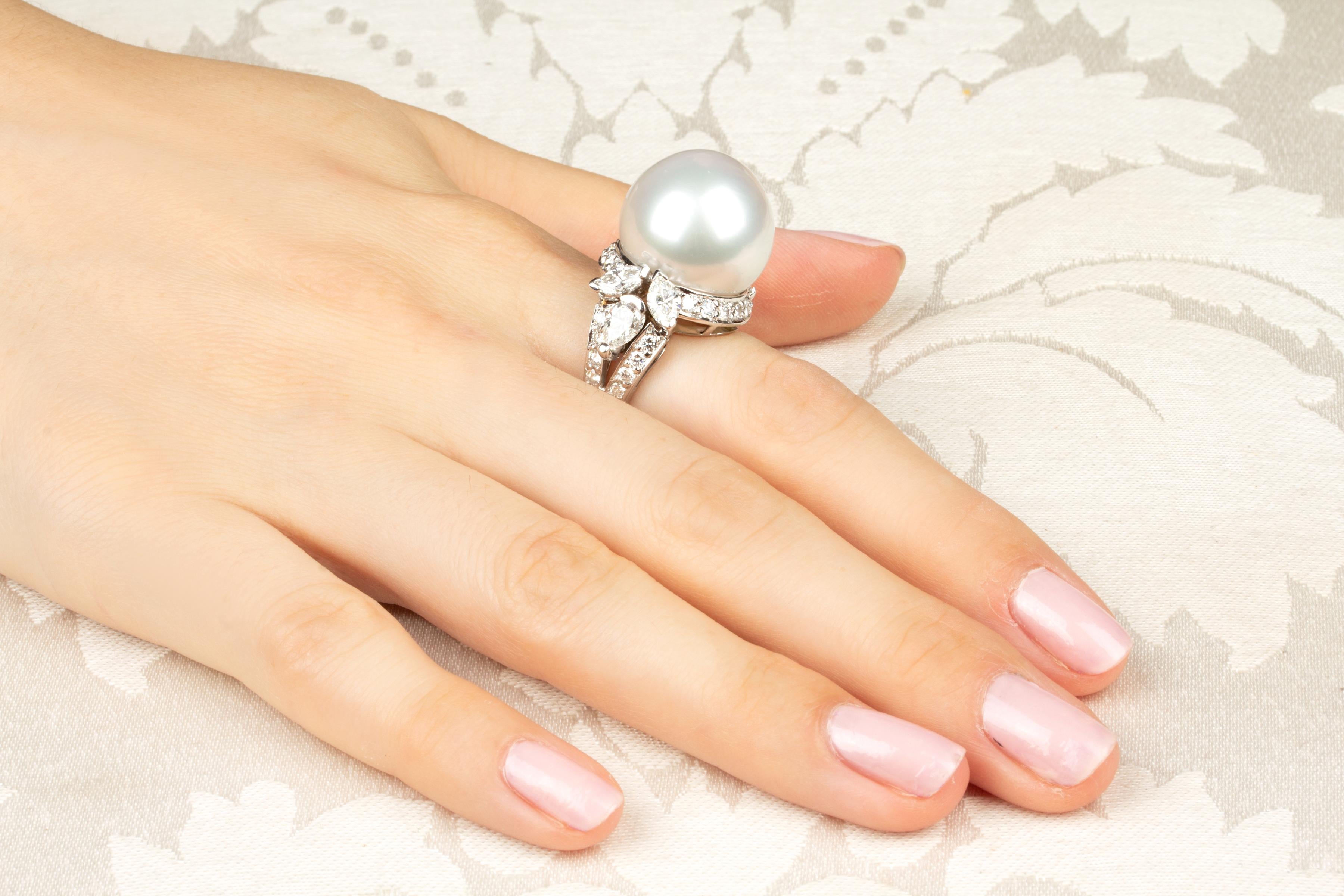 This pearl and diamond ring features a large South Sea pearl of 18mm diameter. The pearl is untreated. It displays a splendid nacre and its natural color and luster have not been enhanced in any way. The pearl is flanked by a leaf-like design with