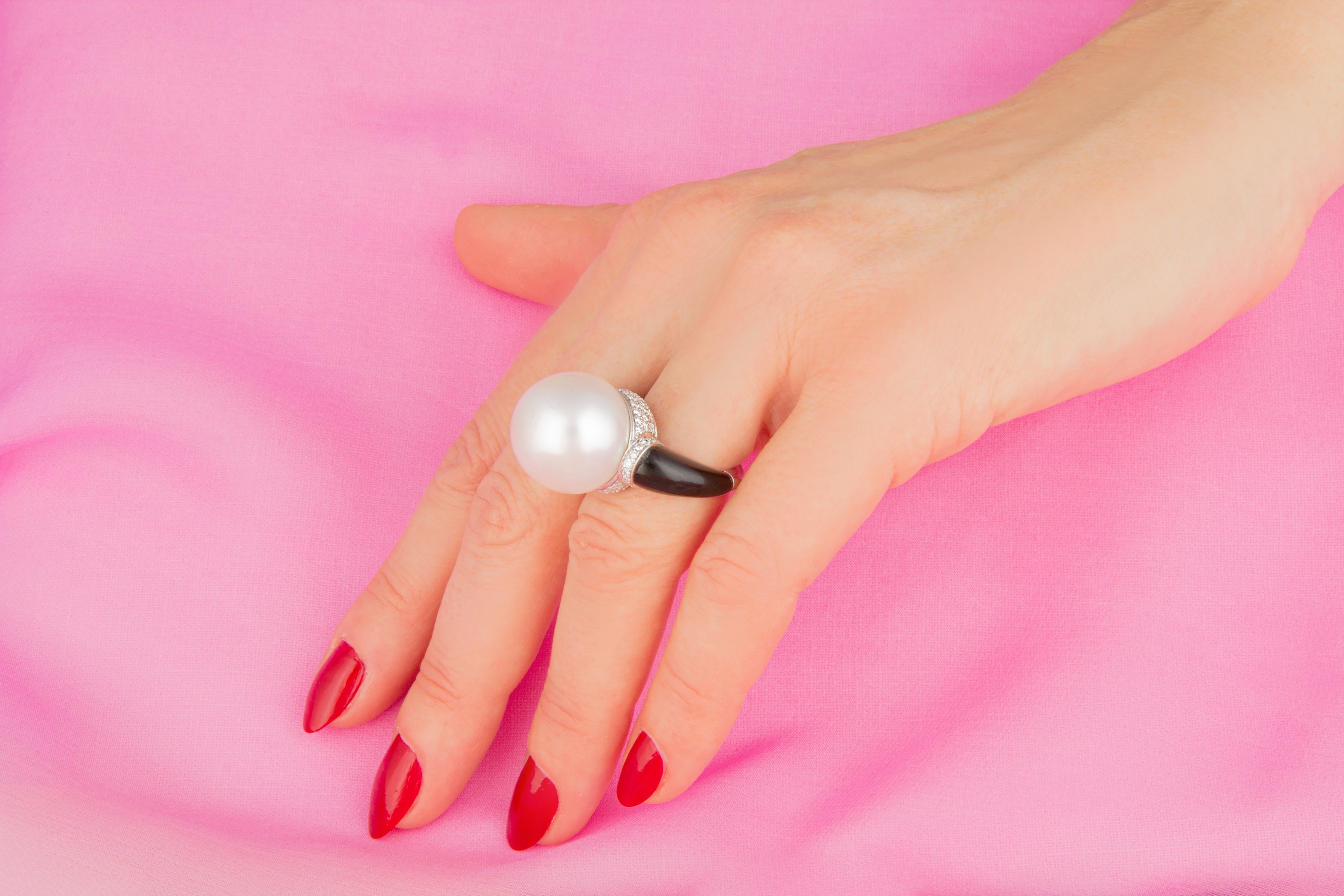 This South Sea pearl and diamond cocktail ring features a large and beautiful pearl of 18mm diameter. The pearl is untreated. It displays a fine nacre and its natural color and luster have not been enhanced in any way. The pearl is perched on a