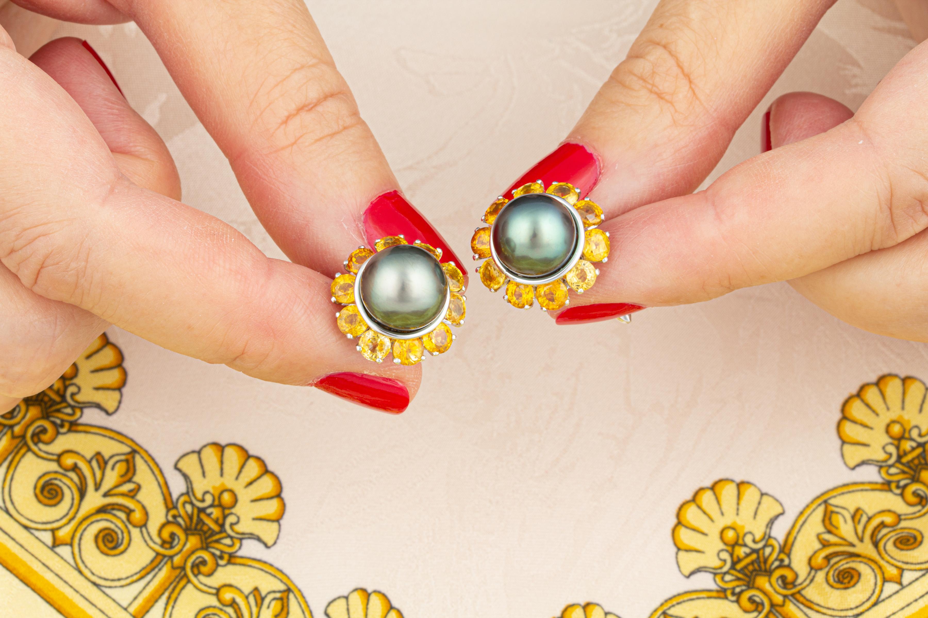 Les boutons de manchette en forme de perles présentent deux perles brillantes provenant des eaux de la Polynésie française. Les perles non traitées ont un diamètre de 10 mm. Ils reposent sur une couronne de saphirs jaunes facettés de taille