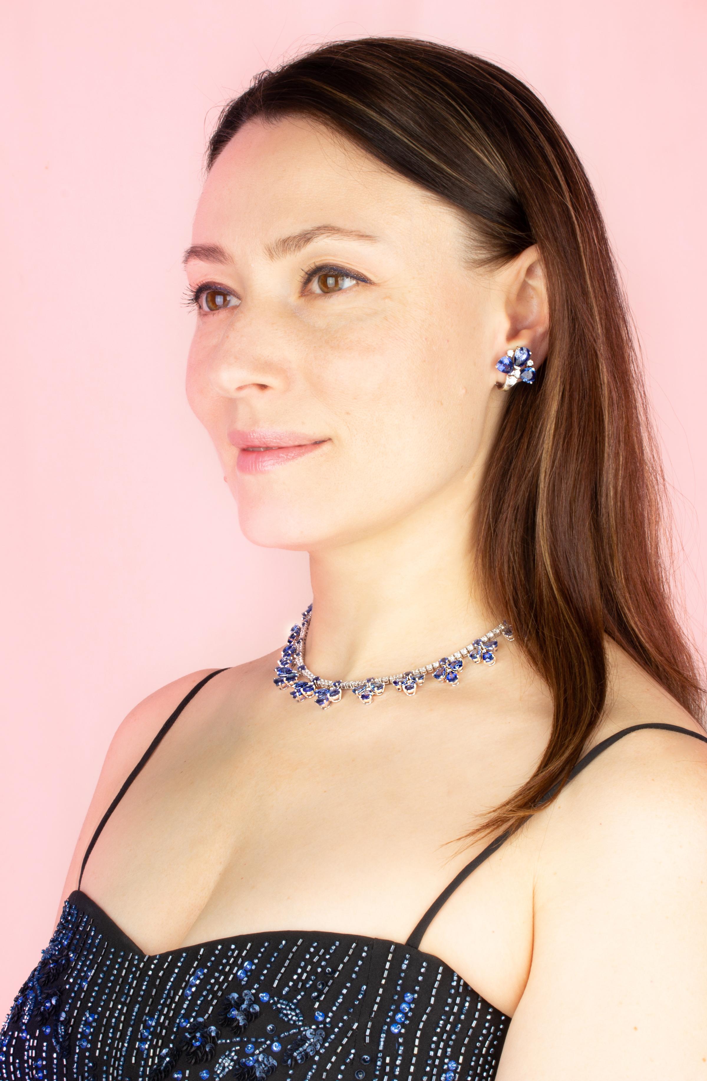 The blue sapphire and diamond flower necklace consists of 13 articulated flowers set with drop shape faceted sapphires of brilliant color. The flower designs are slightly graduated in symmetrical fashion and are attached to a riviera of round