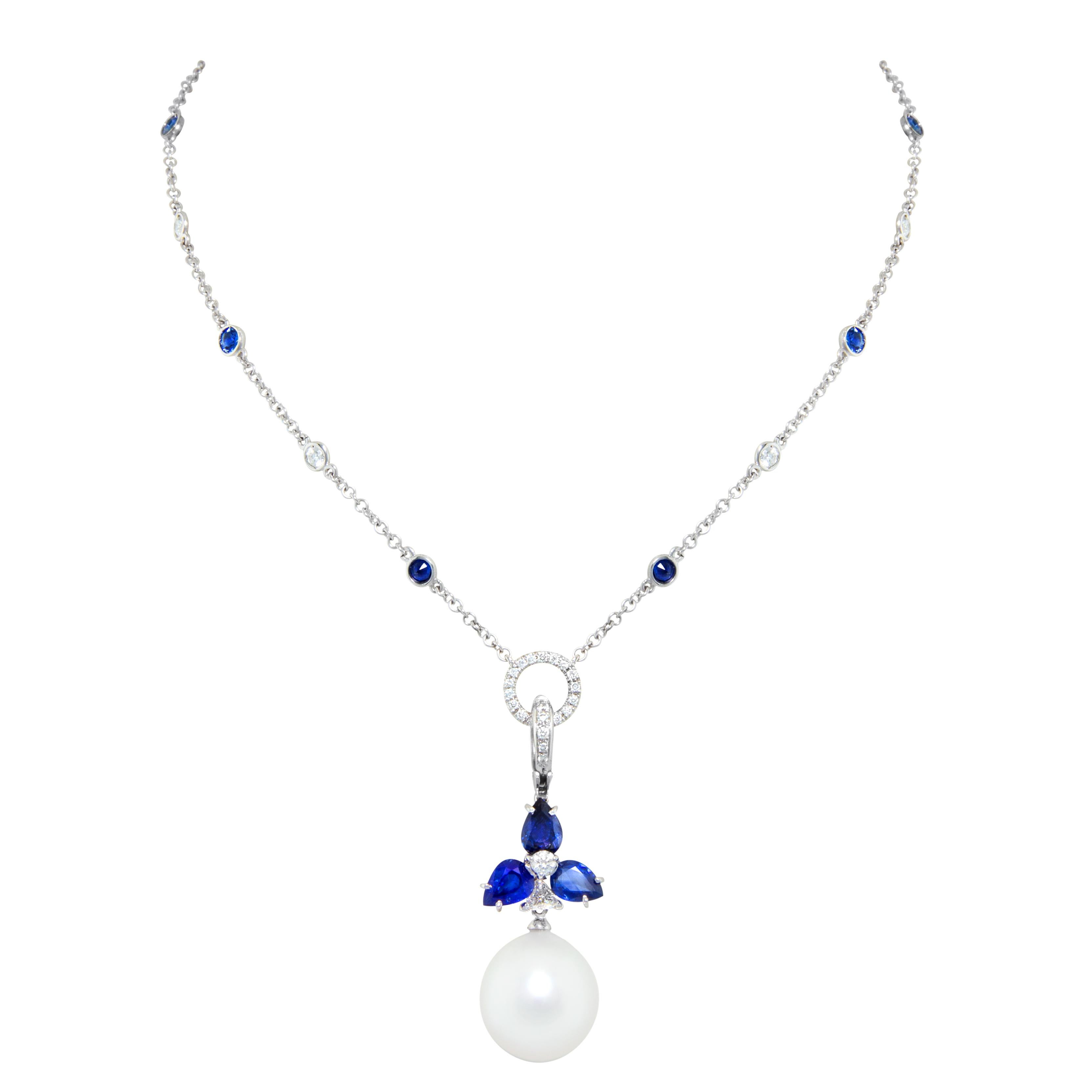 The blue sapphire pendant features a flower set with 4.20 carats of drop shape faceted blue sapphires suspending a lustrous Australian South Sea pearl of 17mm diameter by means of a triangle-cut diamond. The total weight of diamonds in the pendant