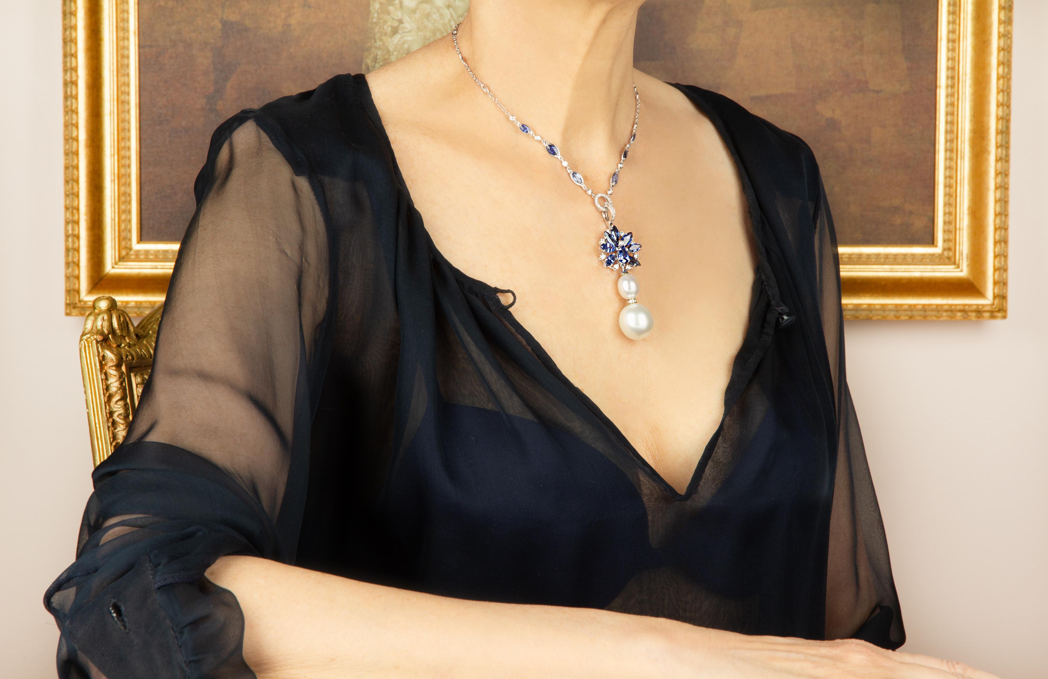 Le pendentif en saphir bleu présente une gerbe de saphirs de Ceylan facettés en forme de marquise, piquetés d'une couronne de diamants ronds. Le bijou suspend 2 splendides perles des mers du Sud, la plus grande étant de la taille très rare de 19 x