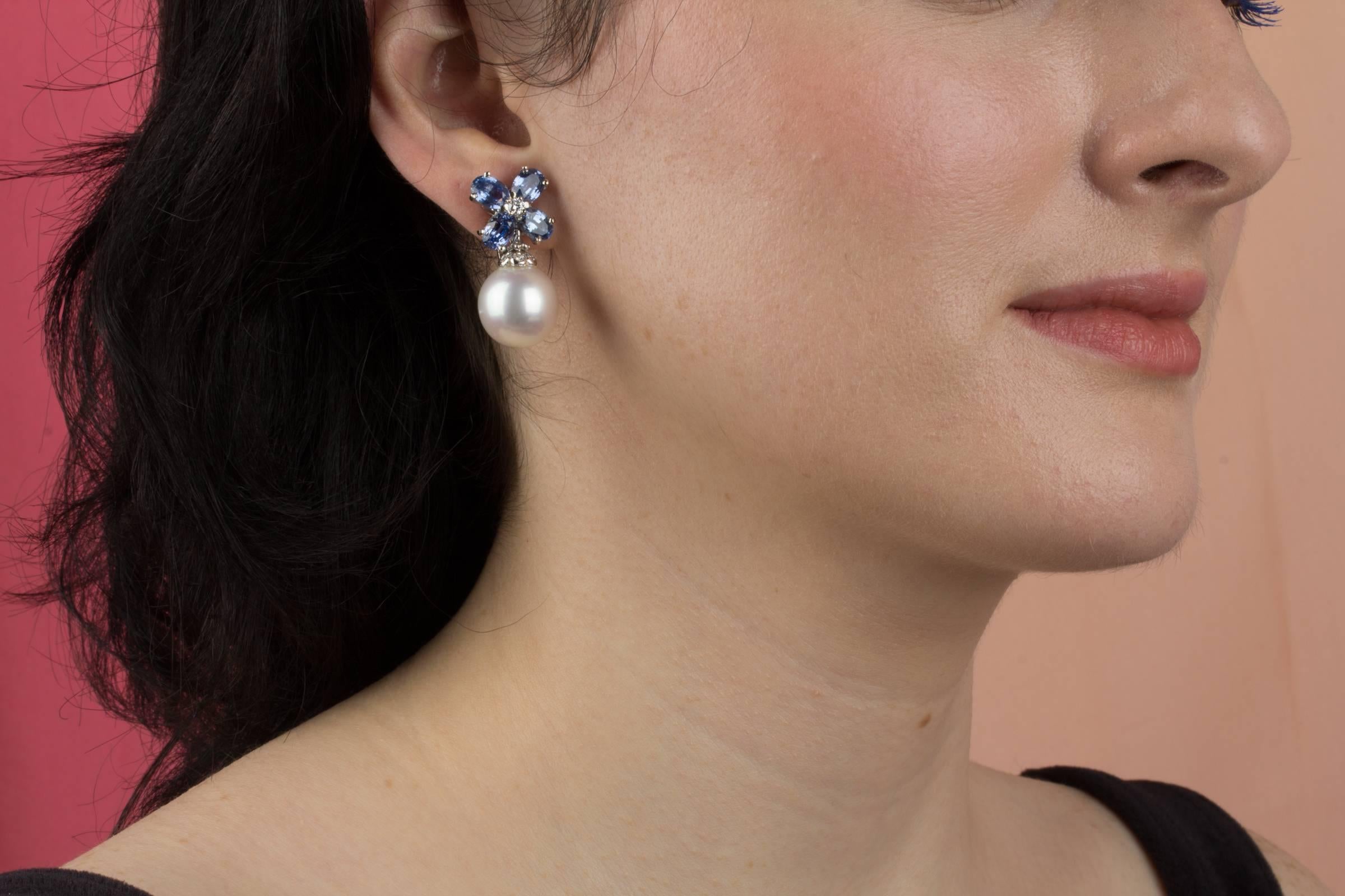 This pair of earrings features a flower design on the ear with 6.50 carats of oval cut faceted blue Ceylon sapphires. The tops suspend 2 South Sea pearls of 15 x 14.5 diameter. 0.30 carats of round diamonds complete the design.
All of our pearls are