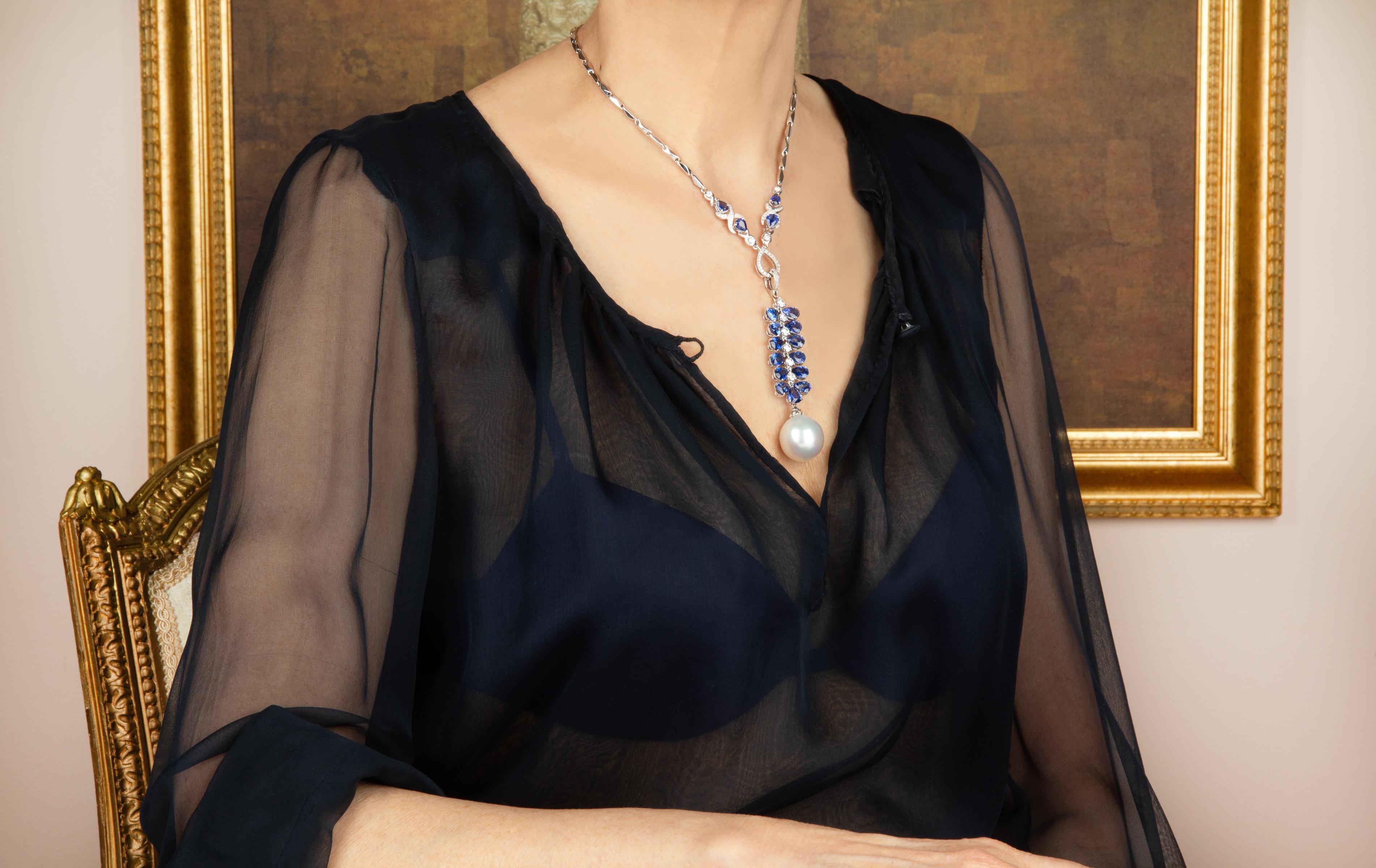 Le pendentif présente une vigne articulée de saphirs bleus de Ceylan facettés en forme de goutte, flanquée d'une colonne vertébrale de diamants ronds. Le bijou suspend une splendide perle des mers du Sud d'une taille extraordinaire : 20 x 19mm. Le