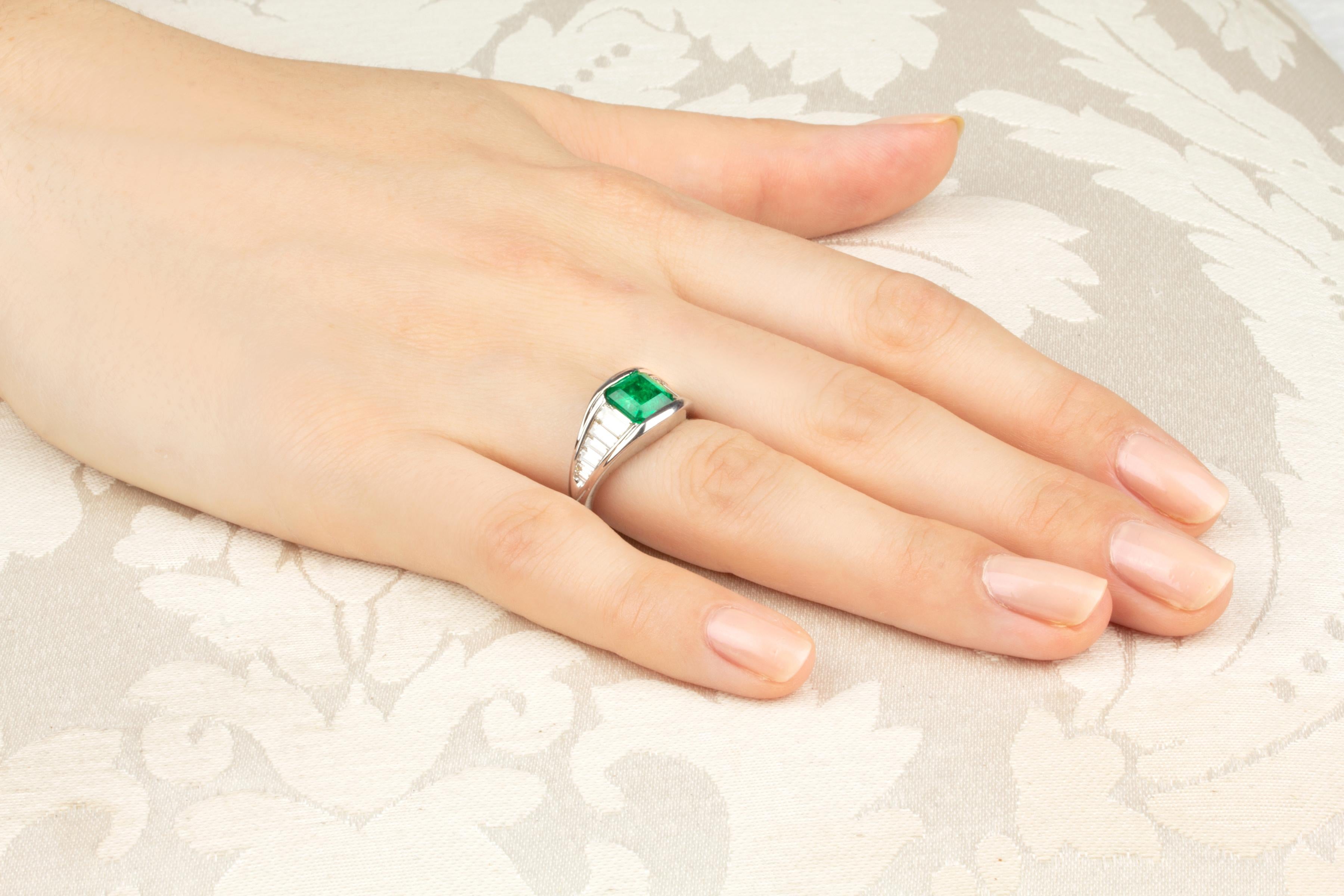 Der Ring besteht aus einem feurigen Smaragd (1,65 Karat) im Smaragdschliff, flankiert von sich verjüngenden Reihen von Baguette-Diamanten im Sonderschliff (1,20 Karat). Alle unsere Diamanten sind von höchster Qualität (Farbe, Reinheit und Schliff,