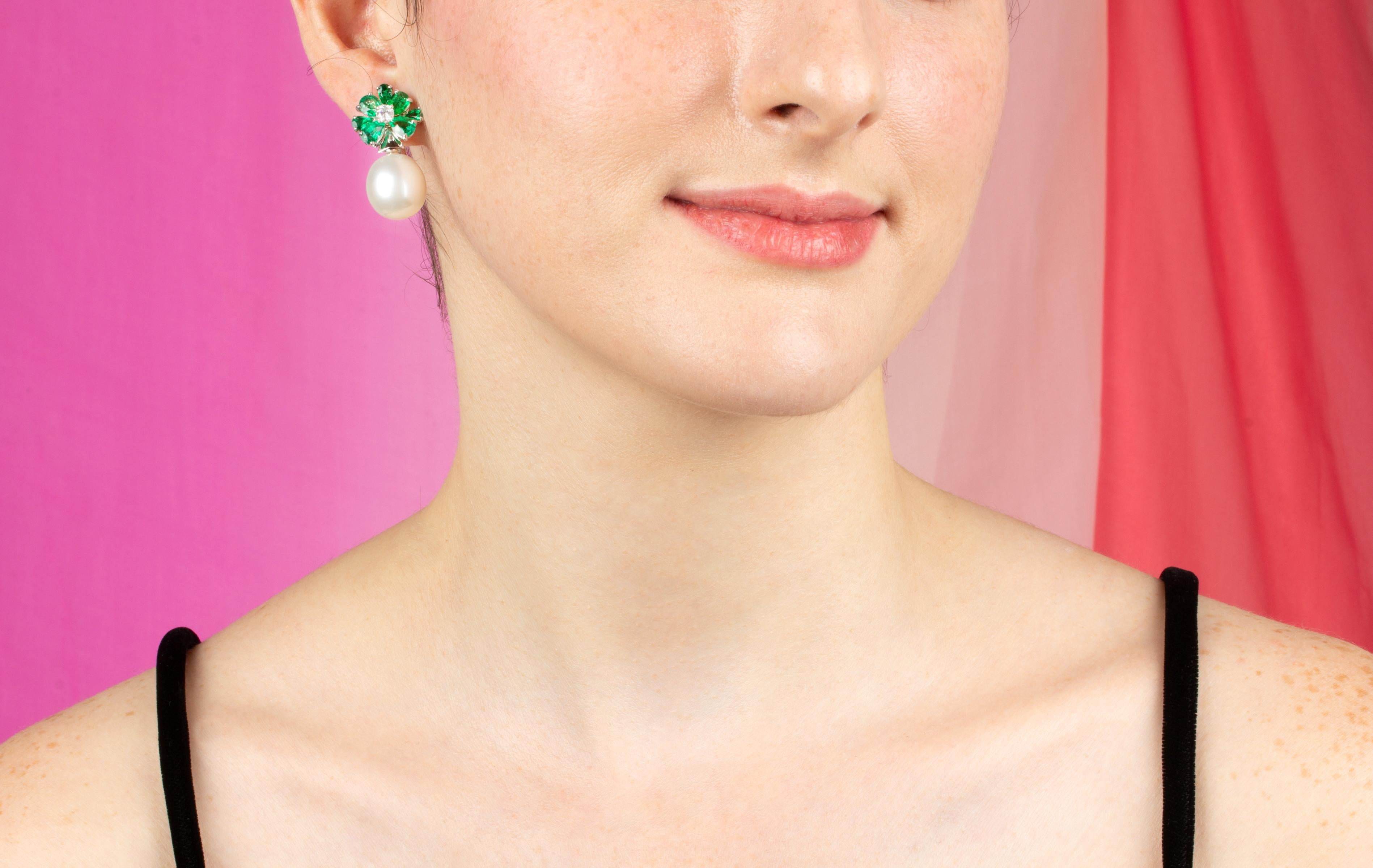 Los pendientes de esmeralda y perlas de los Mares del Sur presentan un diseño floral en la oreja. Está engastado con 5,35 quilates de esmeraldas de Zambia facetadas en forma de gota de calidad cristalina y color brillante. De la parte superior