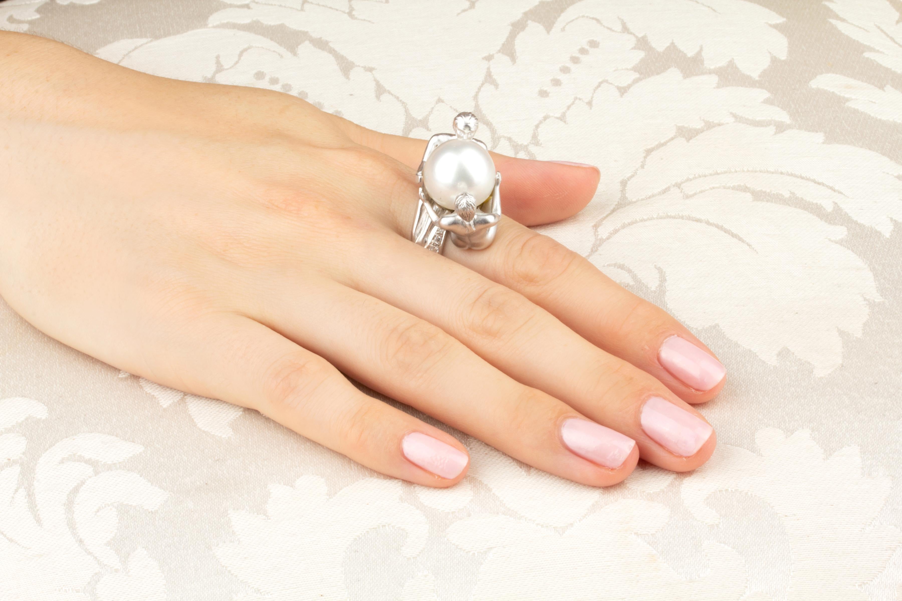 The zodiac Gemini ring features a South Sea pearl of 15mm diameter embraced by a male and a female figure, both sculpted in detail. The pearl is untreated. It displays fine nacre and its natural color and luster have not been enhanced in any way.