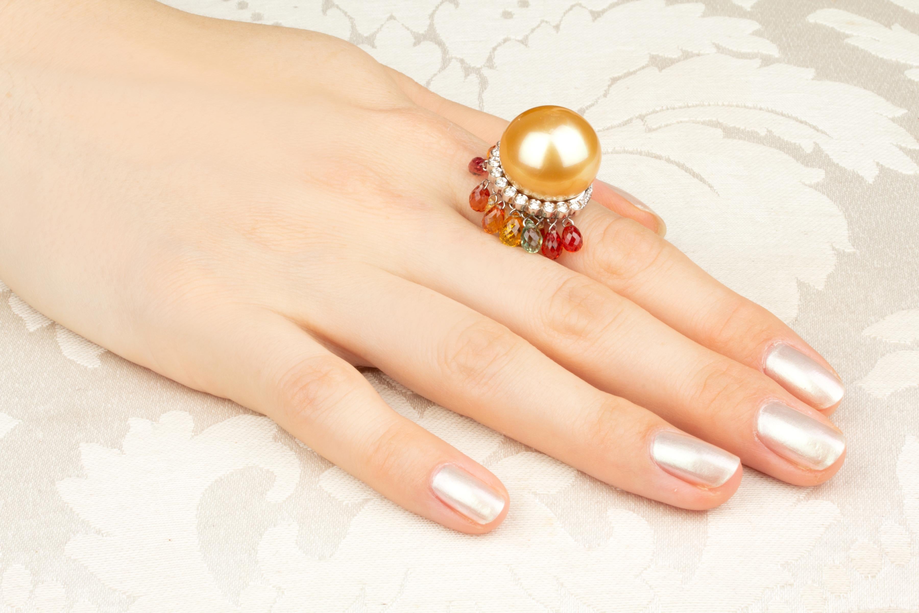 This golden pearl and diamond cocktail ring features a splendid pearl of the rare size of 18mm diameter. The pearl is untreated. It displays a fine nacre and its natural color and luster have not been enhanced in any way. The pearl is perched on a